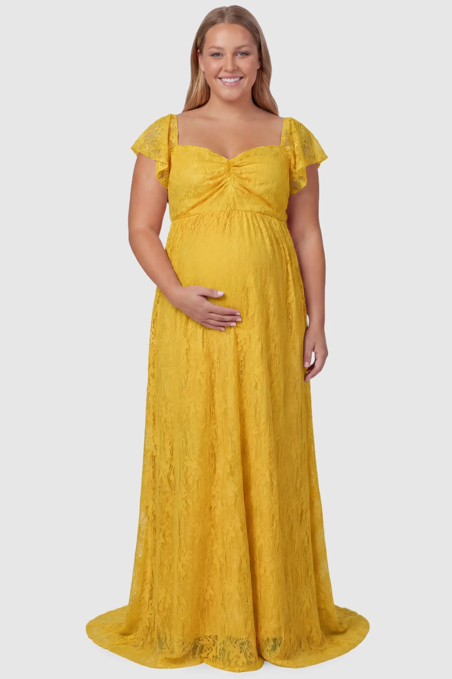 Lace Off Shoulder Maternity Maxi Dress Lace Off Shoulder Maternity Maxi Dress in ginger yellow featuring a sweetheart neckline with a ruched bust and a full-length skirt, shown on a plus size pregnant model, front view.