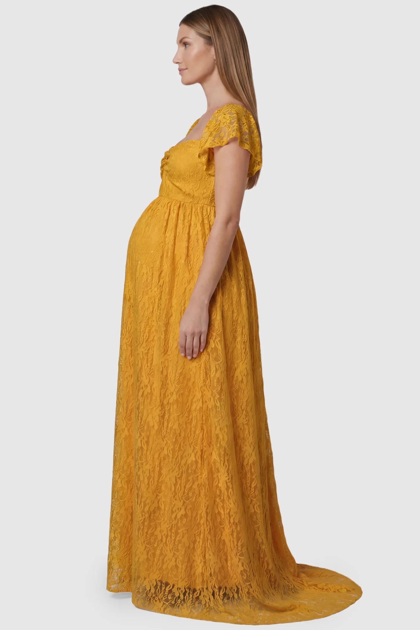 Lace Off Shoulder Maternity Maxi Dress Lace Off Shoulder Maternity Maxi Dress in gold featuring a sweetheart neckline with a ruched bust and a full-length skirt, shown on a pregnant model, side view.