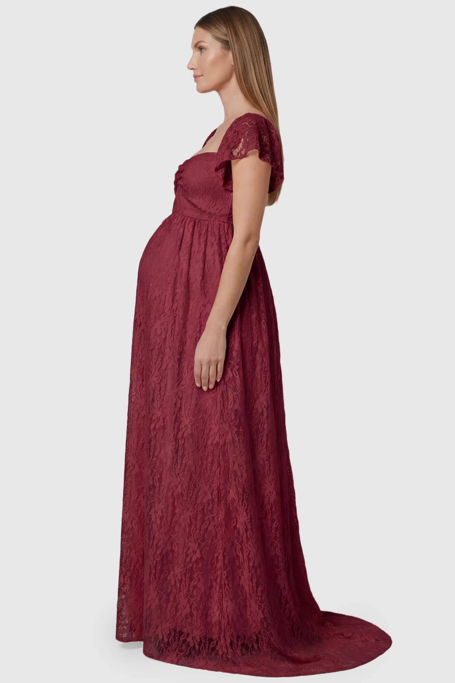 Lace Off Shoulder Maternity Maxi Dress Lace Off Shoulder Maternity Maxi Dress in wine red featuring a sweetheart neckline with a ruched bust and a full-length skirt, shown on a pregnant model, side view.