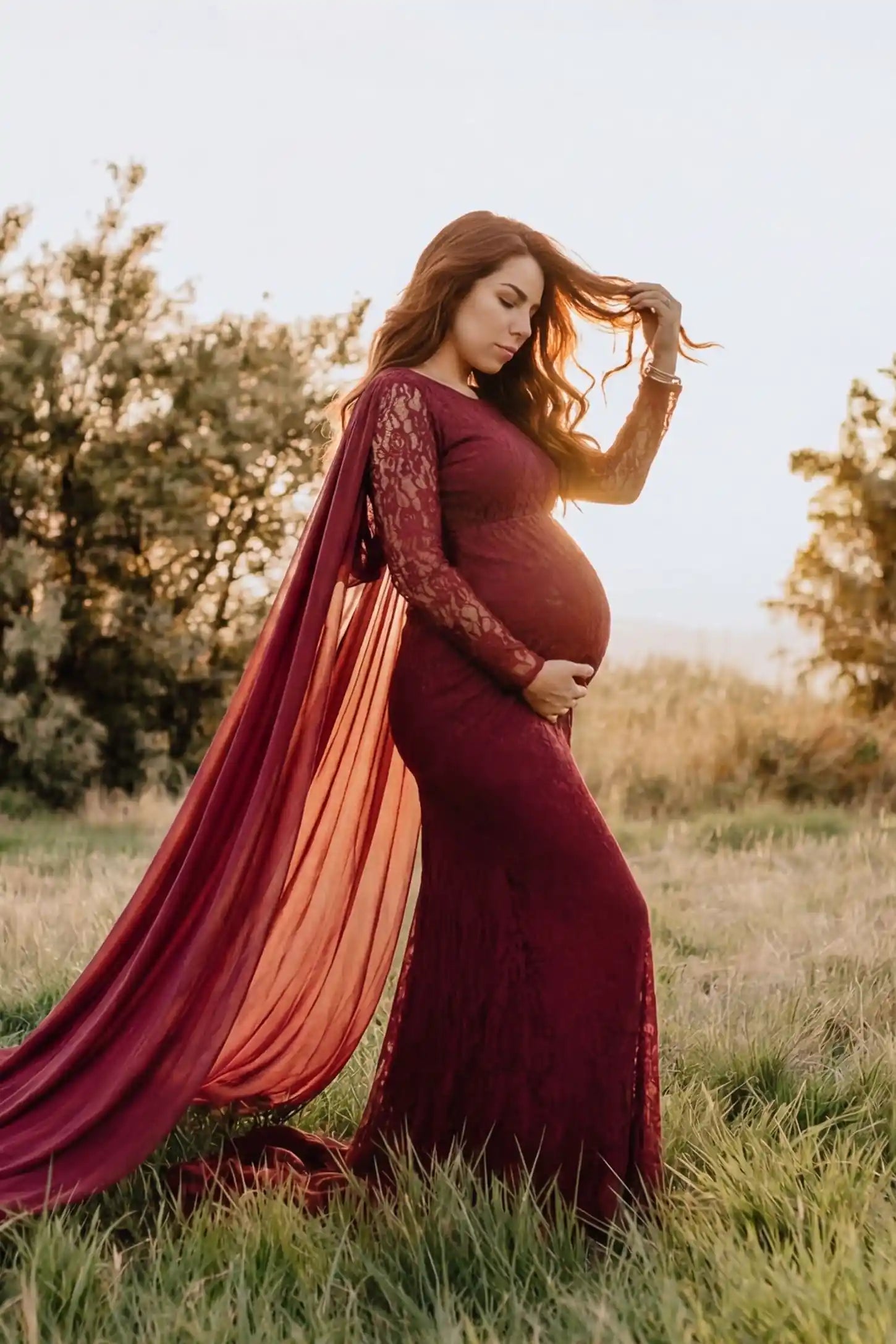 Lace & Chiffon Spliced Long Sleeve Maternity Photoshoot Gown Lace & Chiffon Spliced Maternity Photoshoot Gown in Wine Red featuring a sheer draped cape on a pregnant model side view.