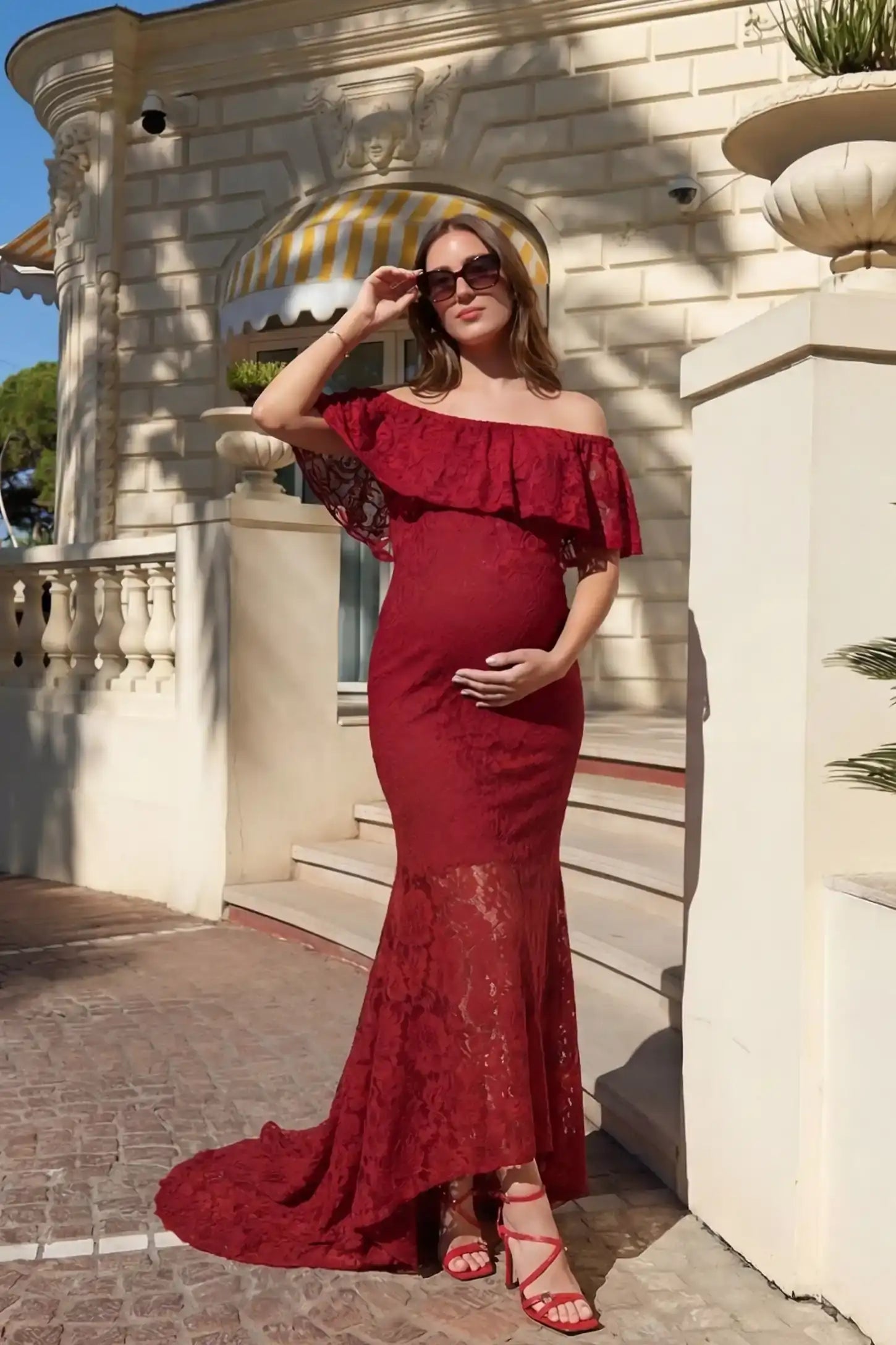 Lace Off-the-Shoulder Flutter Sleeve Maternity Maxi Dress Lace Off-the-Shoulder Flutter Sleeve Maternity Dress in Wine Red featuring floral lace on a front-facing pregnant model.