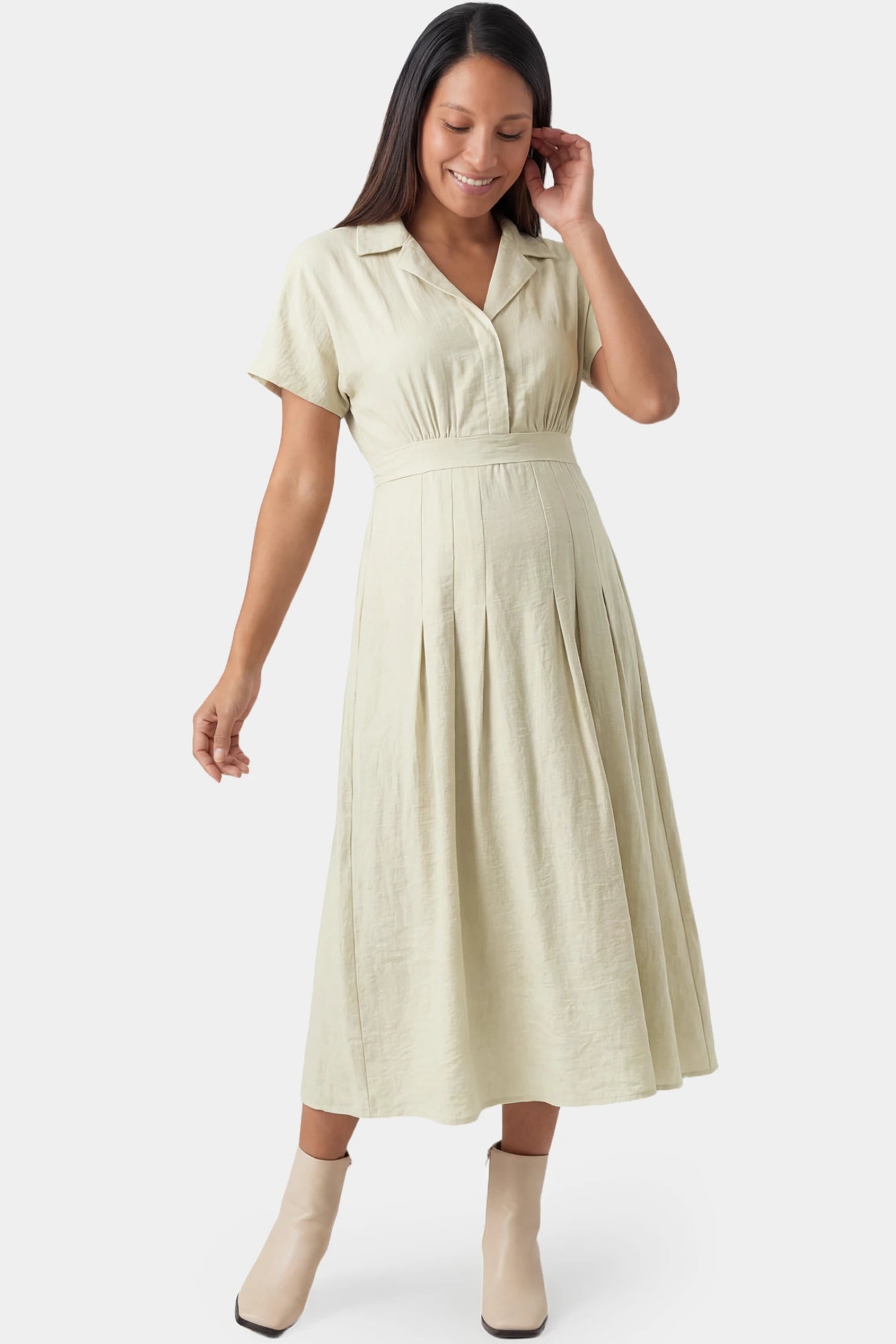 Lapel collar short sleeve A-line midi maternity dress in light green featuring high waisted silhouette in full body front view on a pregnant model