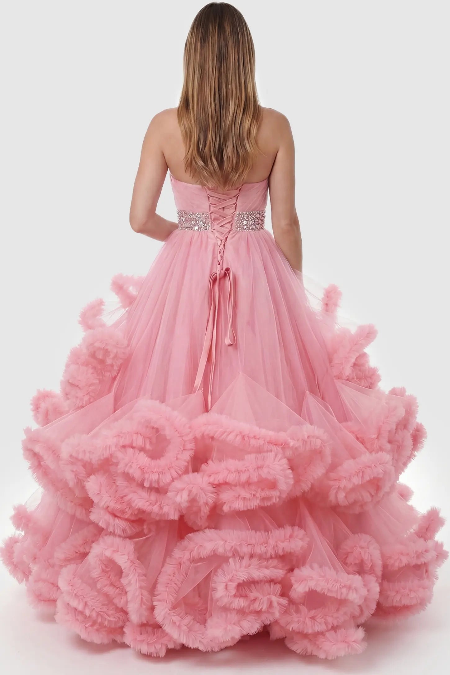Multi-Layered Pleated Tulle Strapless Bodice Maxi Maternity Gown Multi-layered pleated tulle strapless bodice maxi maternity gown in pink featuring elegant ruffled hem in back view on a pregnant model