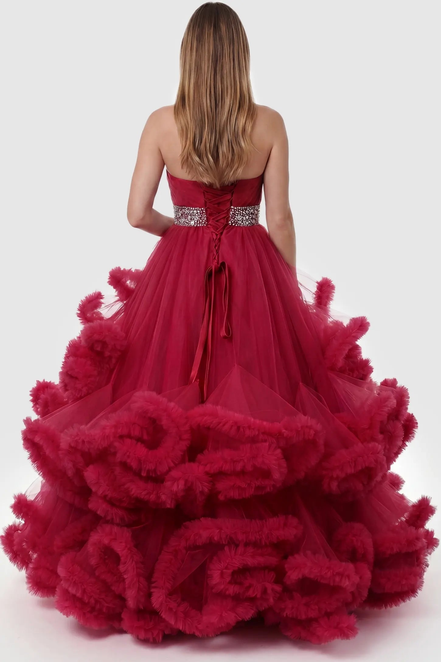 Multi-Layered Pleated Tulle Strapless Bodice Maxi Maternity Gown Multi-layered pleated tulle strapless bodice maxi maternity gown in red featuring elegant ruffled hem in back view on a pregnant model