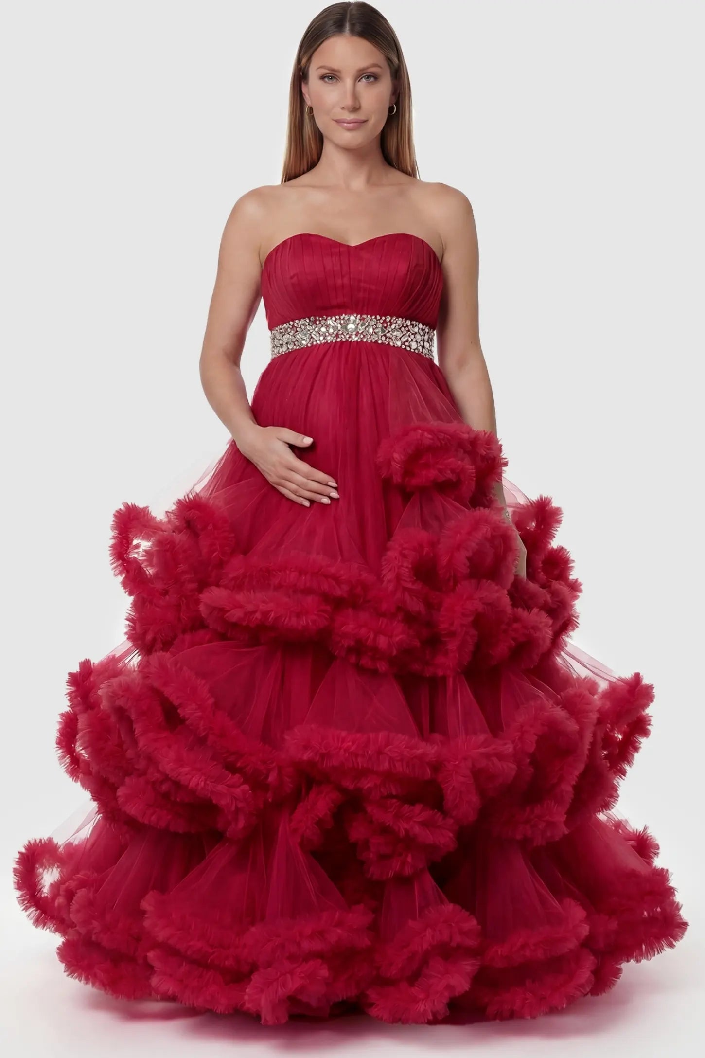 Multi-Layered Pleated Tulle Strapless Bodice Maxi Maternity Gown Multi-layered pleated tulle strapless bodice maxi maternity gown in red featuring structured strapless bodice in front view on a pregnant model