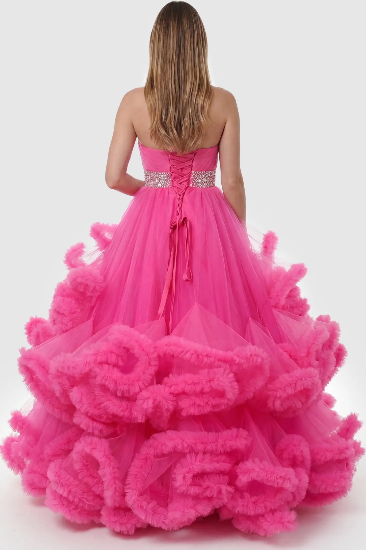 Multi-Layered Pleated Tulle Strapless Bodice Maxi Maternity Gown Multi-layered pleated tulle strapless bodice maxi maternity gown in rose red featuring elegant ruffled hem in back view on a pregnant model