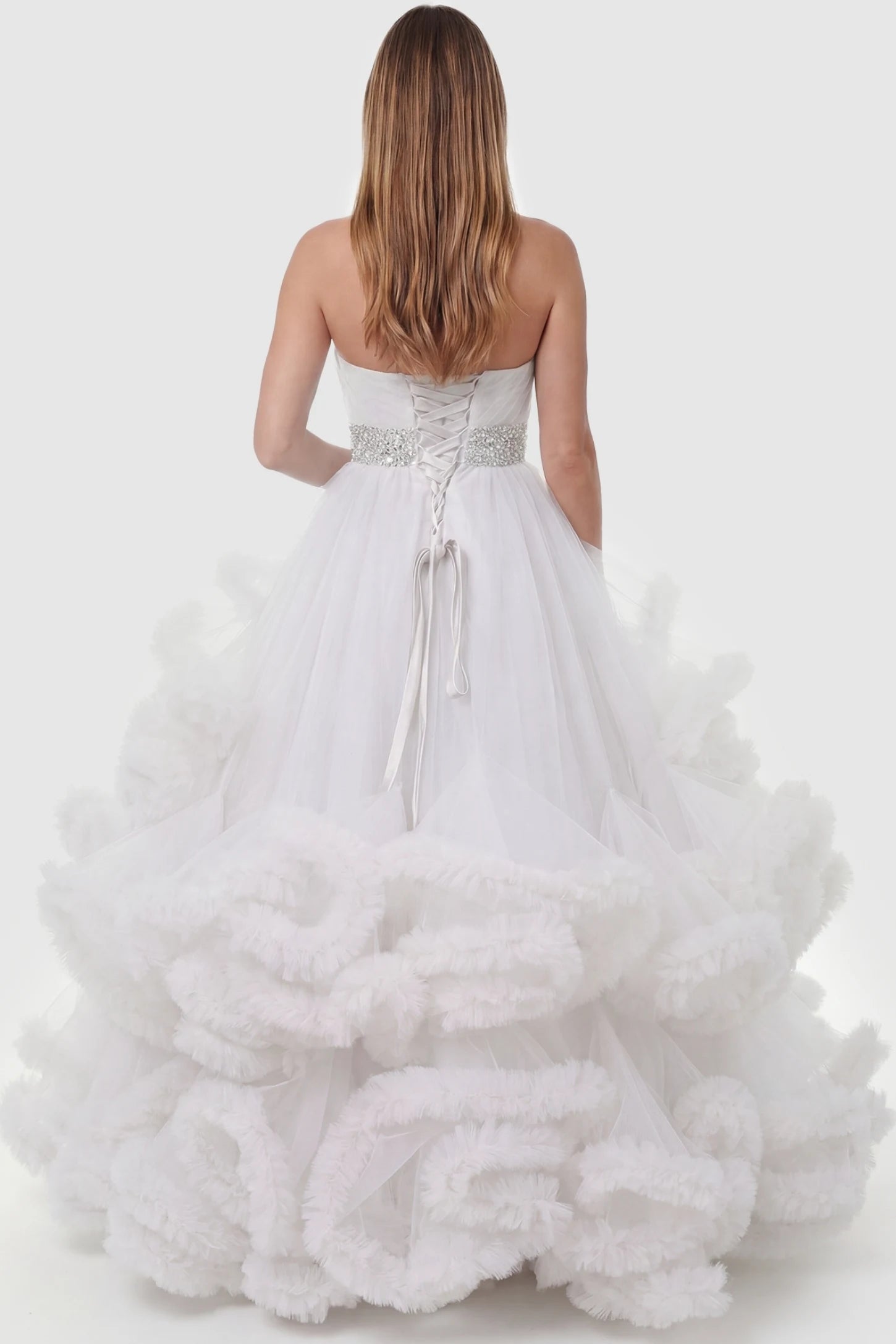 Multi-Layered Pleated Tulle Strapless Bodice Maxi Maternity Gown Multi-layered pleated tulle strapless bodice maxi maternity gown in white featuring elegant ruffled hem in back view on a pregnant model