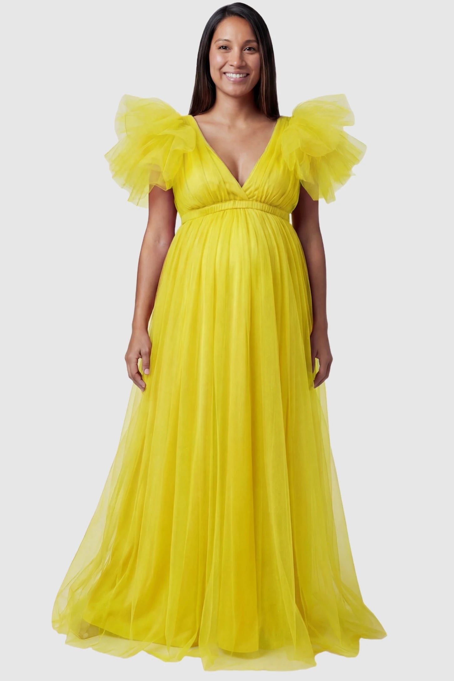 Layered Tulle Ruffle Sleeve Maternity Photoshoot Dress Layered Tulle Ruffle Sleeve Maternity Photoshoot Dress in Lemon Yellow featuring a high-slit front on a pregnant model.