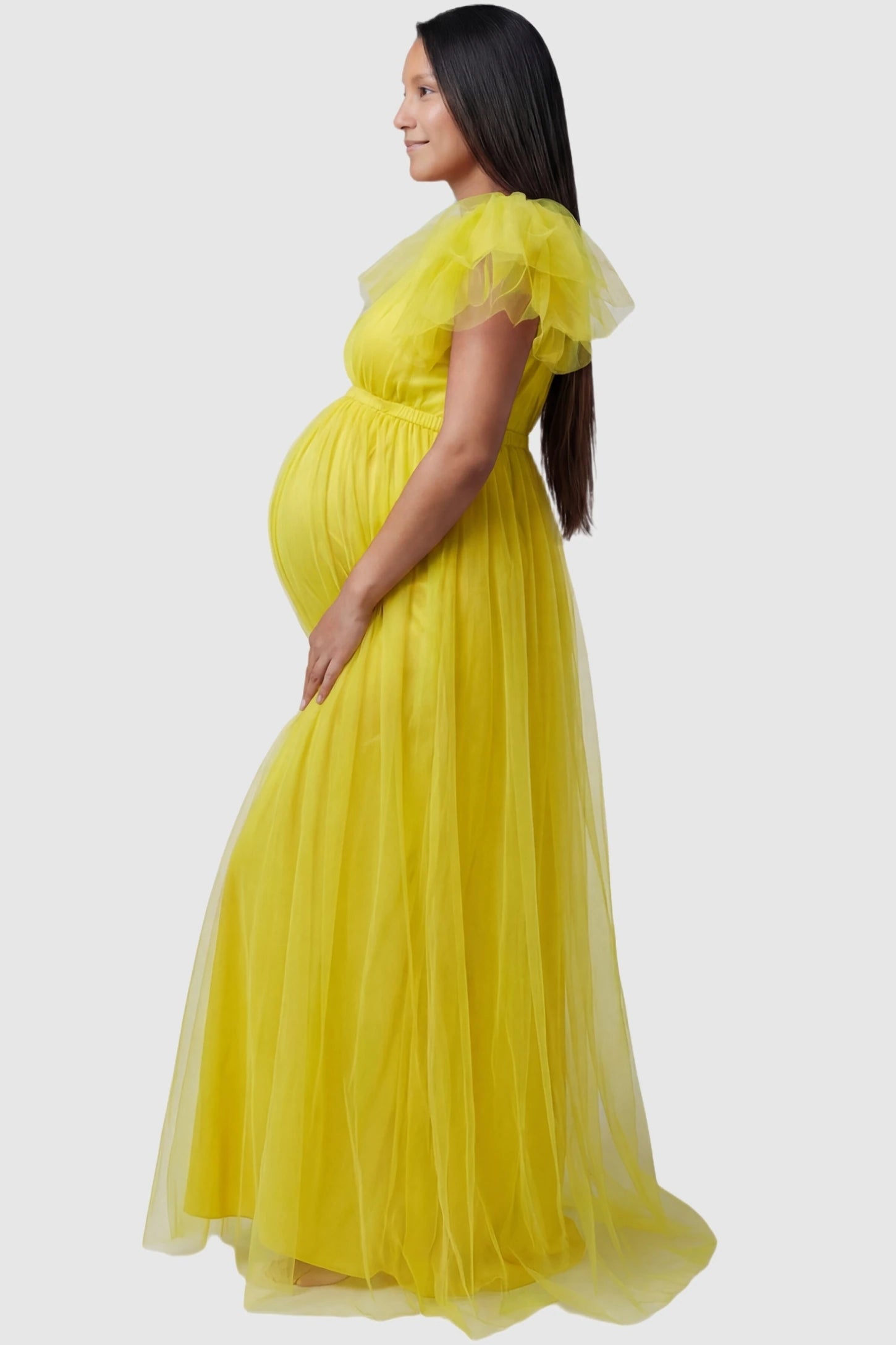 Layered Tulle Ruffle Sleeve Maternity Photoshoot Dress Layered Tulle Ruffle Sleeve Maternity Photoshoot Dress in Lemon Yellow featuring a side slit on a pregnant model.