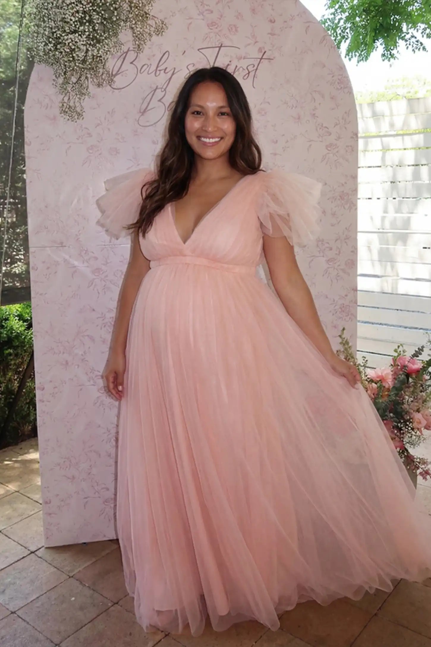 Layered Tulle Ruffle Sleeve Maternity Photoshoot Dress Layered Tulle Ruffle Sleeve Maternity Photoshoot Dress in Pink featuring an empire waist on a pregnant model.