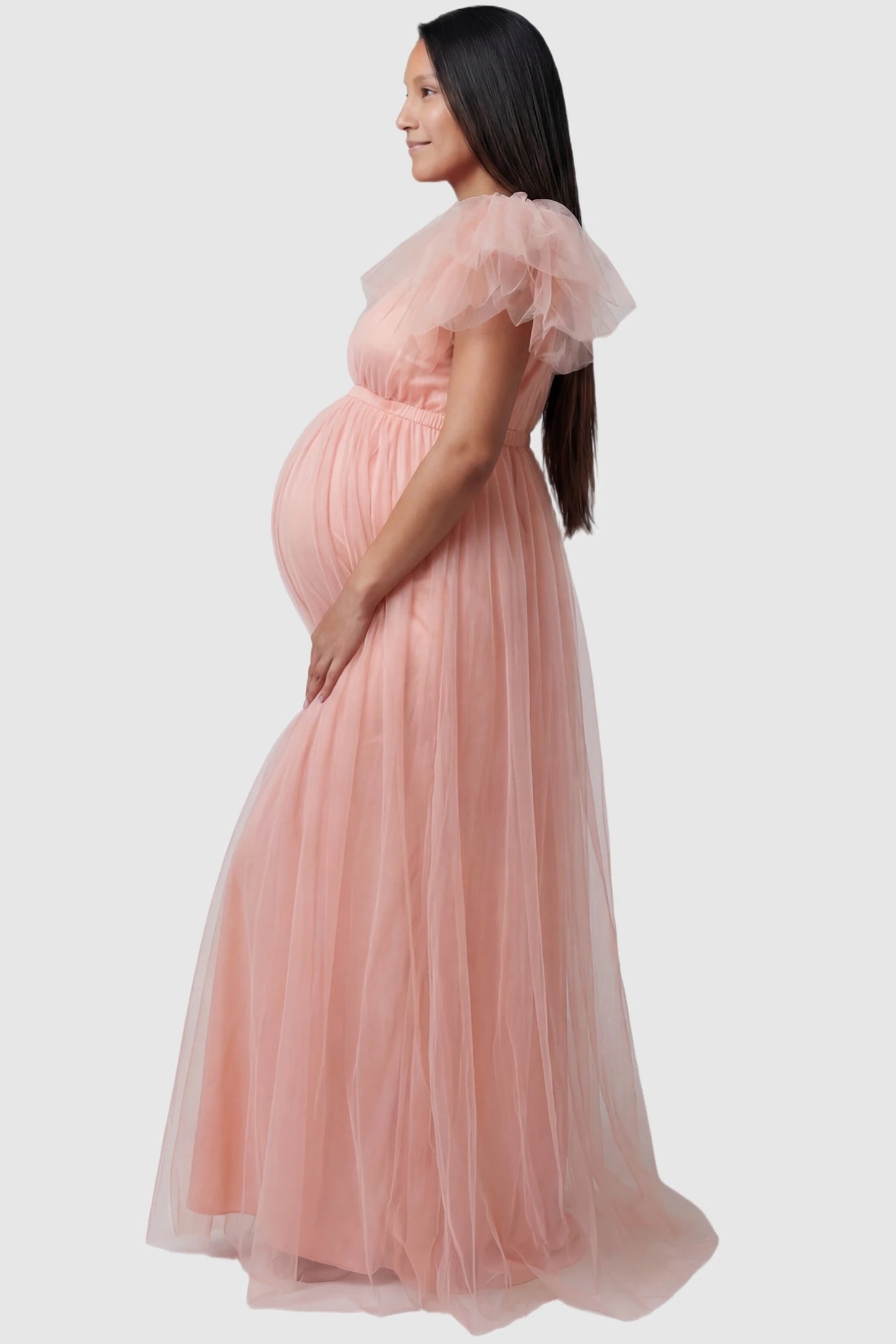 Layered Tulle Ruffle Sleeve Maternity Photoshoot Dress Layered Tulle Ruffle Sleeve Maternity Photoshoot Dress in Pink featuring voluminous mesh ruffles on a pregnant model.