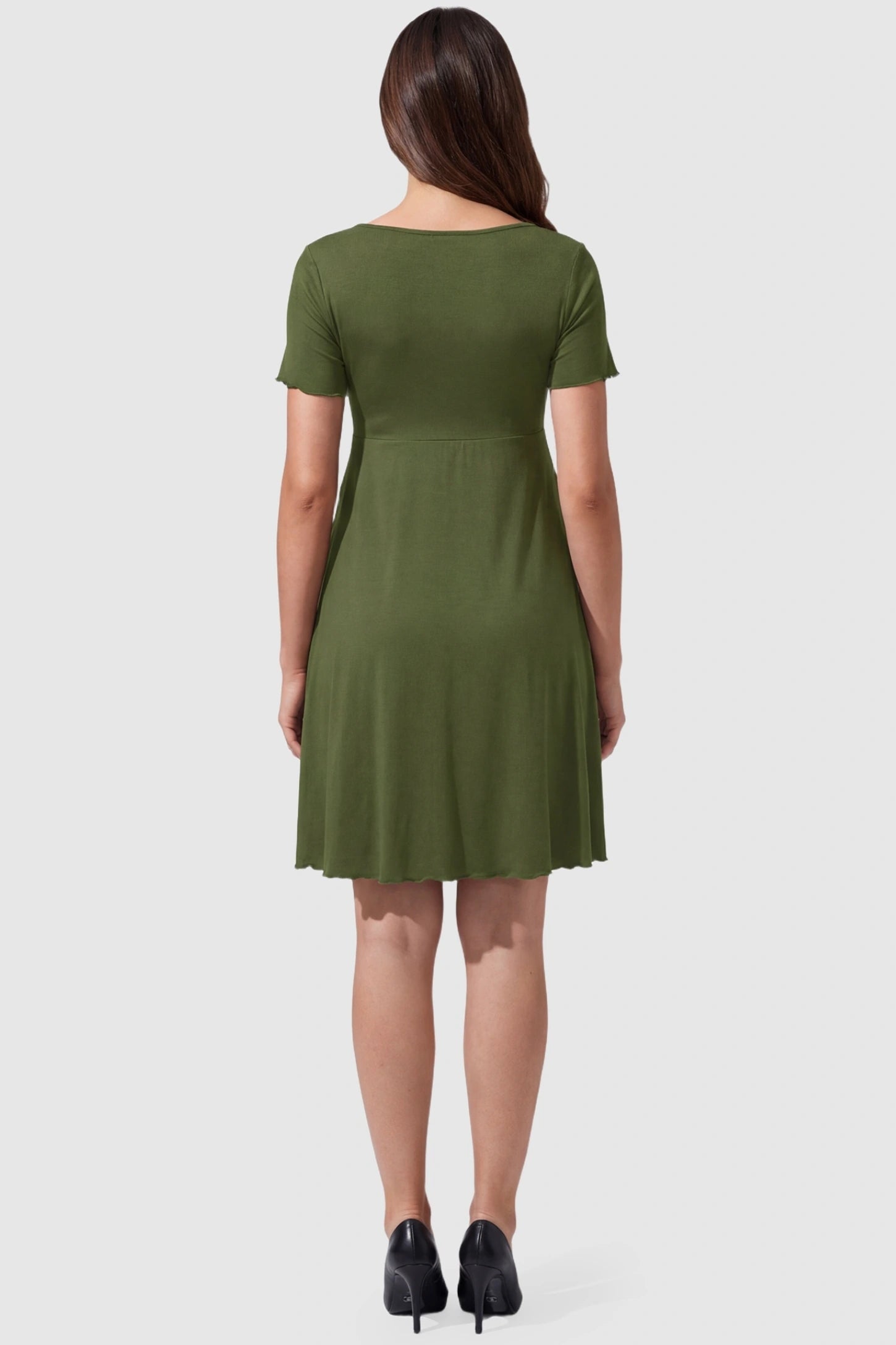 Lettuce Trim A-Line Mini Maternity Dress Lettuce Trim A-Line Mini Maternity Dress in Green featuring an empire waistline on the back of a pregnant model.