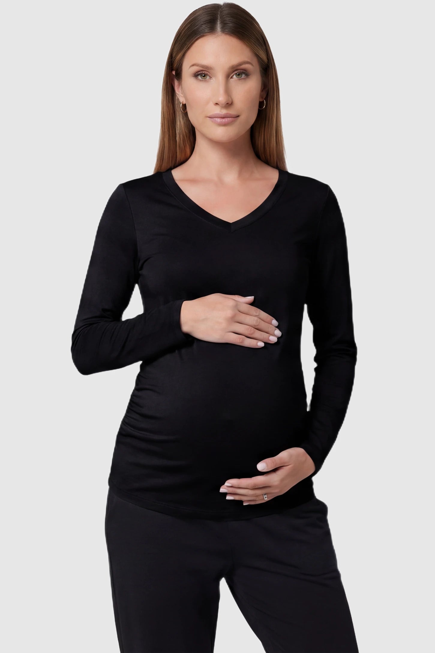 Soft knit long sleeve V-neck maternity top in black with flattering V-neckline and long sleeves, front view on pregnant model