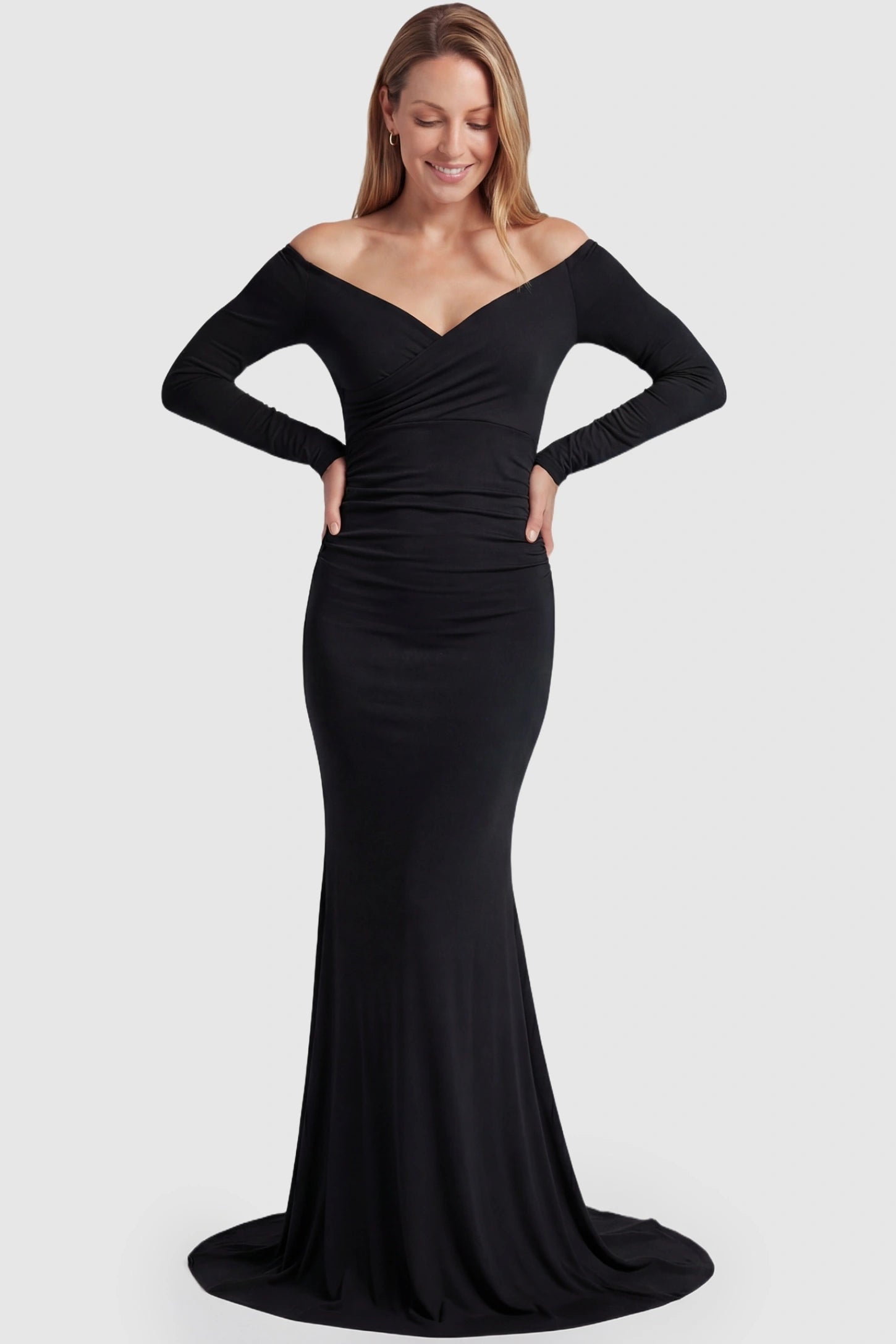 Off-Shoulder Long Sleeve Trailing Maxi Maternity Dress Off-shoulder long sleeve trailing maxi maternity dress in black featuring dramatic full train and elegant long sleeves in full body view on a postpartum model