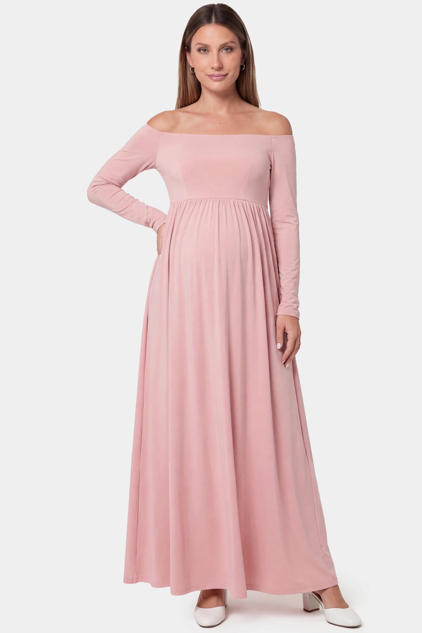 Off-shoulder long sleeve full skirt maxi maternity dress in pink featuring romantic off-shoulder neckline in front view on a pregnant model