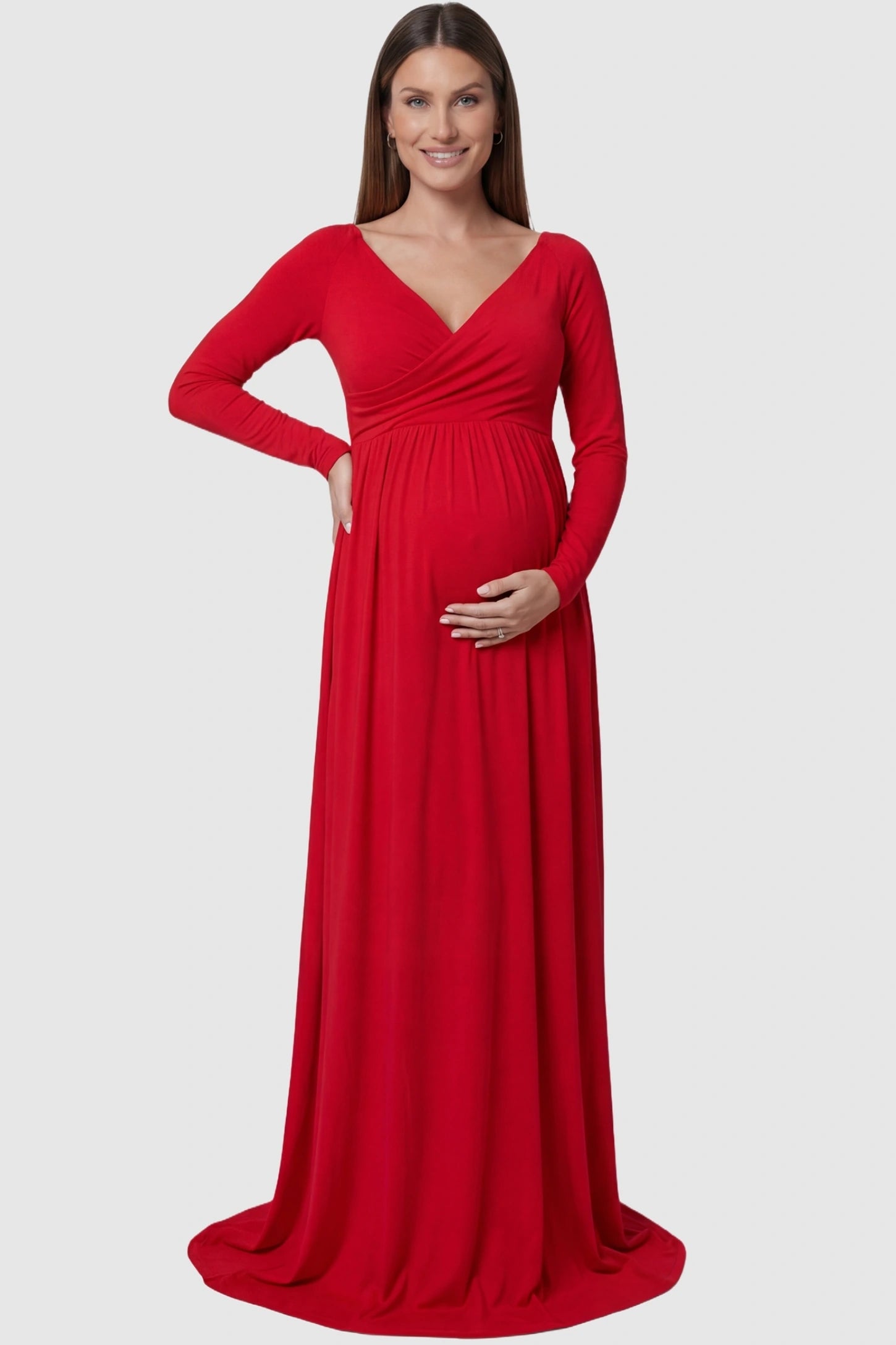Off-shoulder long sleeve trailing maxi maternity dress in red featuring an elegant long sleeve silhouette in front view on a pregnant model