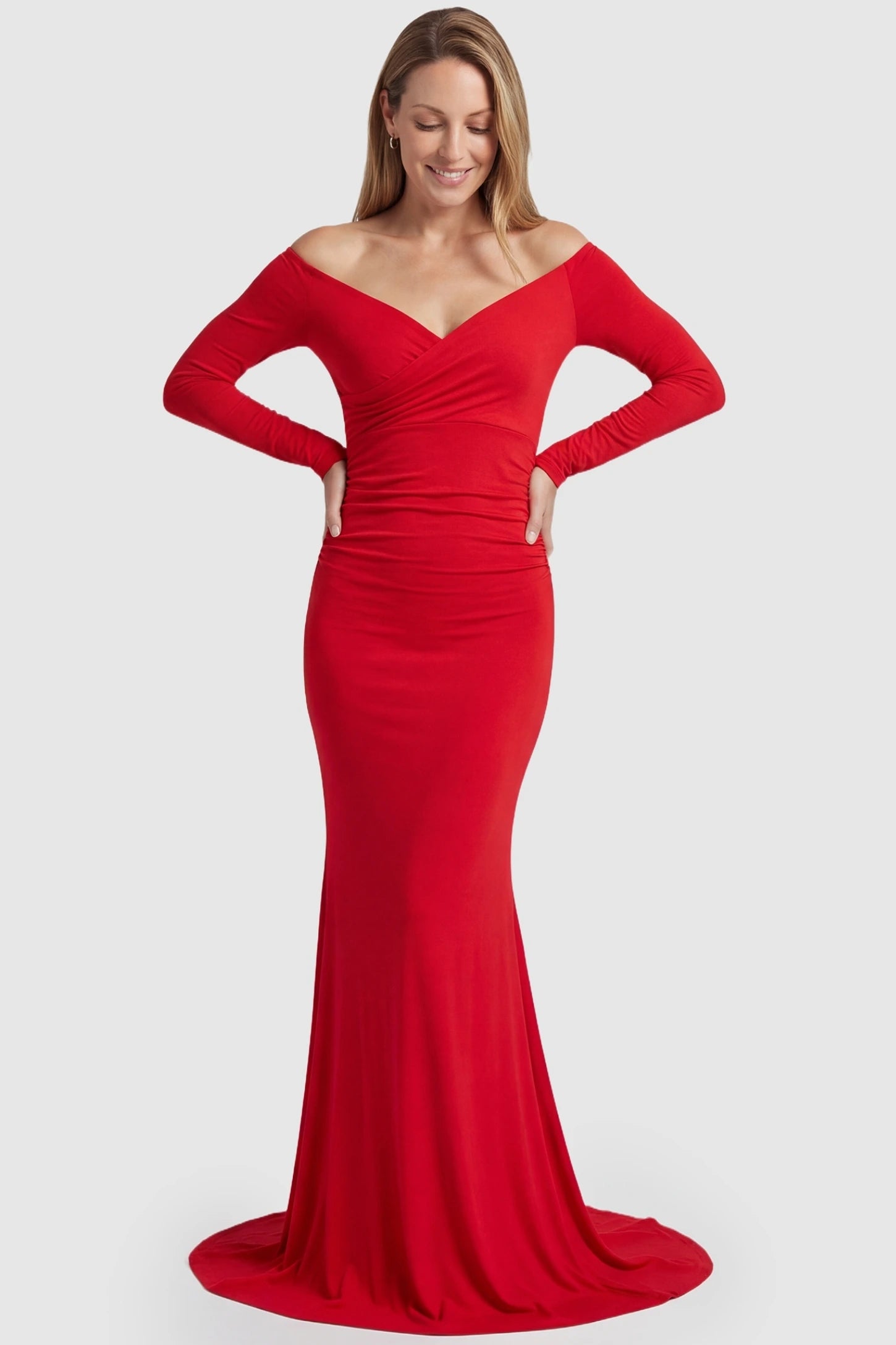 Off-Shoulder Long Sleeve Trailing Maxi Maternity Dress Off-shoulder long sleeve trailing maxi maternity dress in red featuring dramatic full train and elegant long sleeves in full body view on a postpartum model