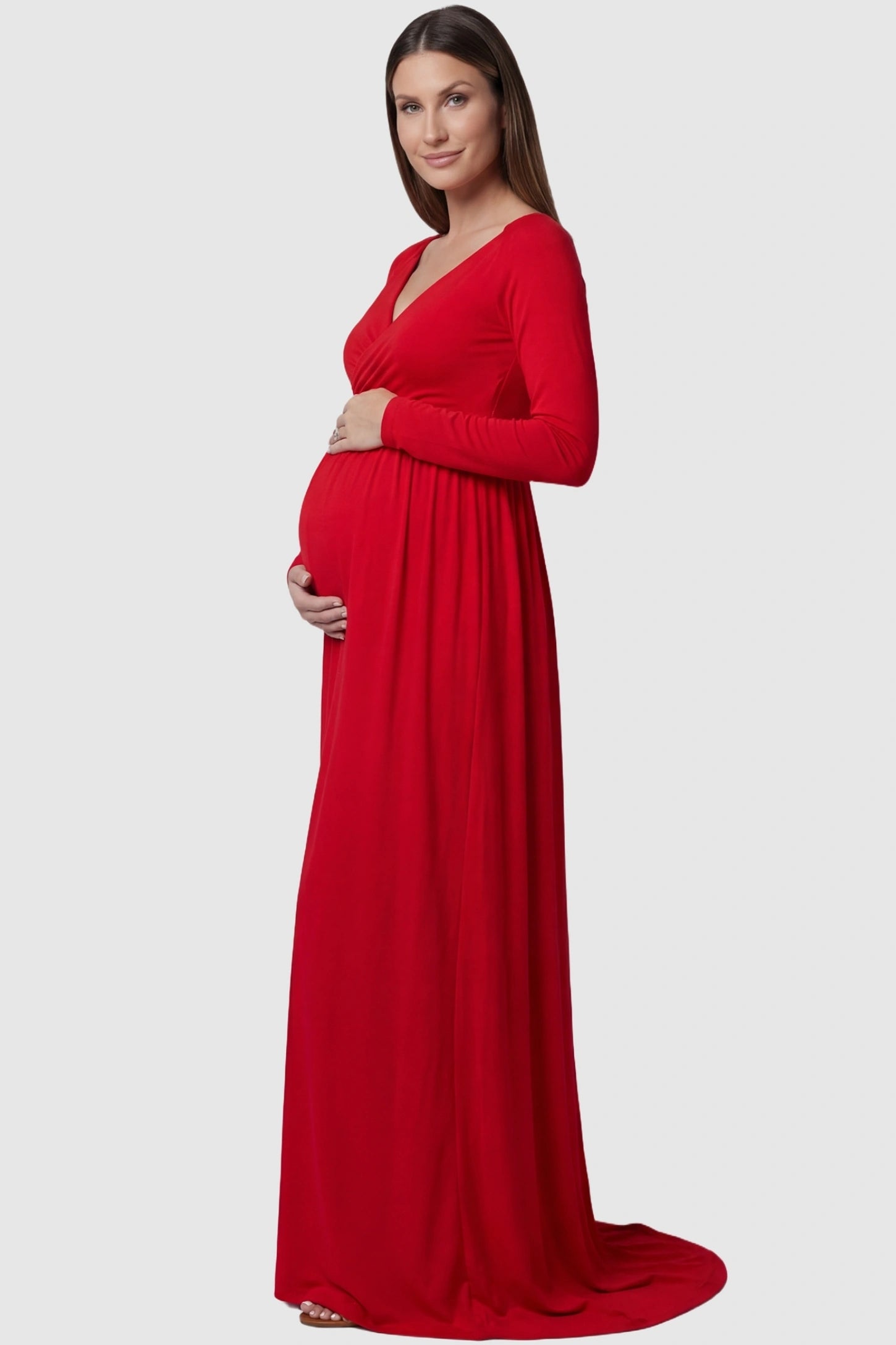 Off-shoulder long sleeve trailing maxi maternity dress in red featuring elegant long sleeve silhouette in side view on a pregnant model