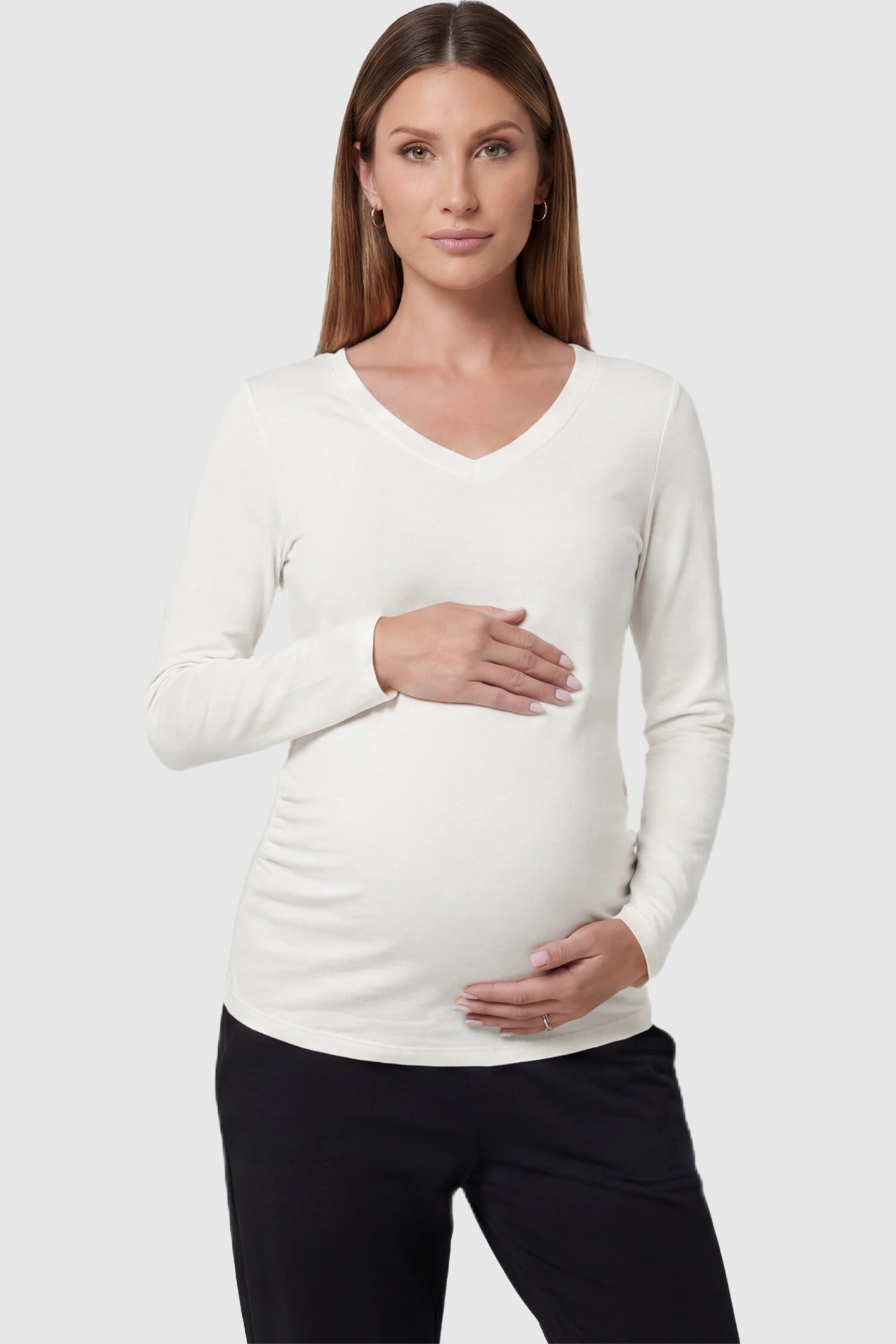 Soft Knit Long Sleeve V-Neck Maternity Top Soft knit long sleeve V-neck maternity top in white with flattering V-neckline and long sleeves, front view on pregnant model