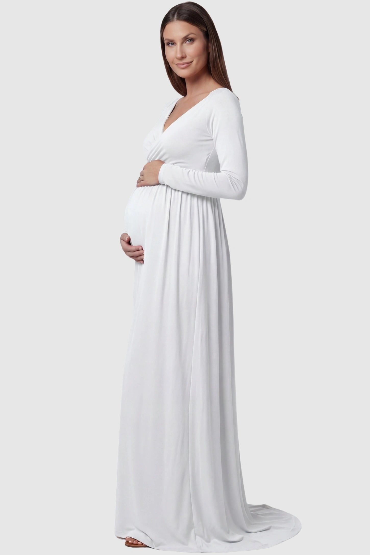 Off-Shoulder Long Sleeve Trailing Maxi Maternity Dress Off-shoulder long sleeve trailing maxi maternity dress in white featuring elegant long sleeve silhouette in side view on a pregnant model
