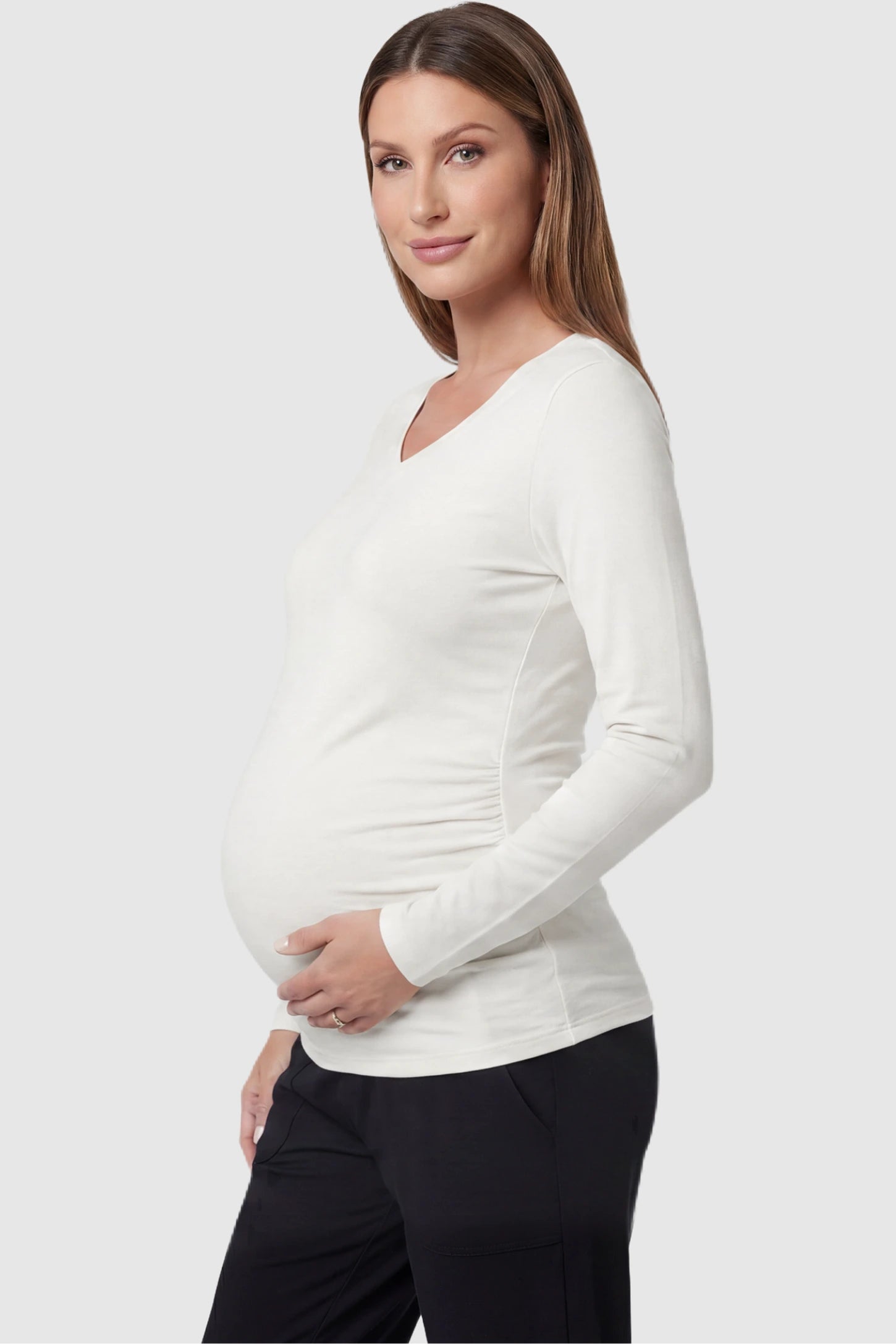 Soft Knit Long Sleeve V-Neck Maternity Top Soft knit long sleeve V-neck maternity top in white with flattering V-neckline and long sleeves, side view on pregnant model