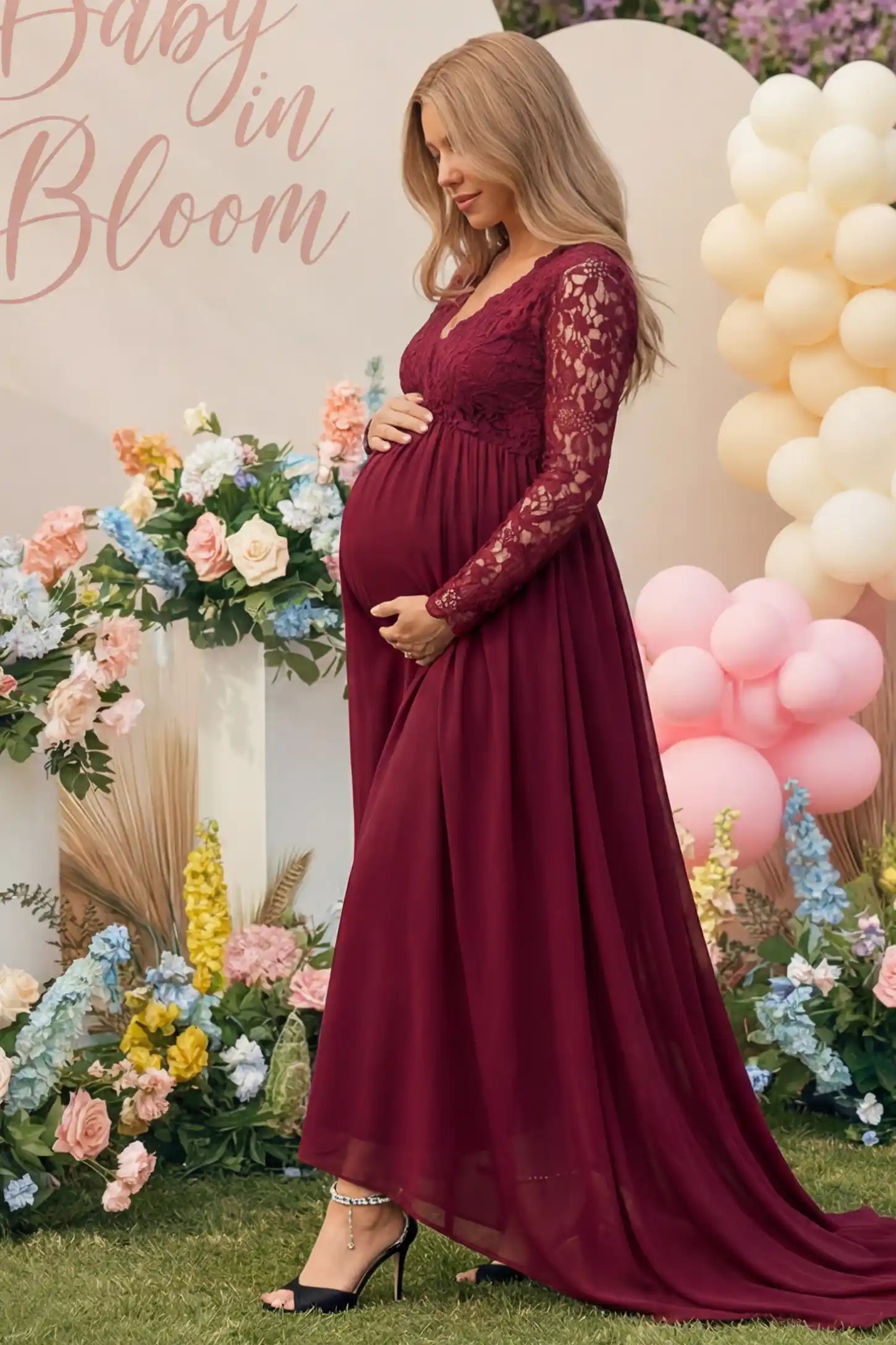 Lace Long Sleeve Full Skirt Maxi Maternity Dress Lace long sleeve full skirt maxi maternity dress in burgundy with elegant long sleeves & lace bodice, side view on pregnant model