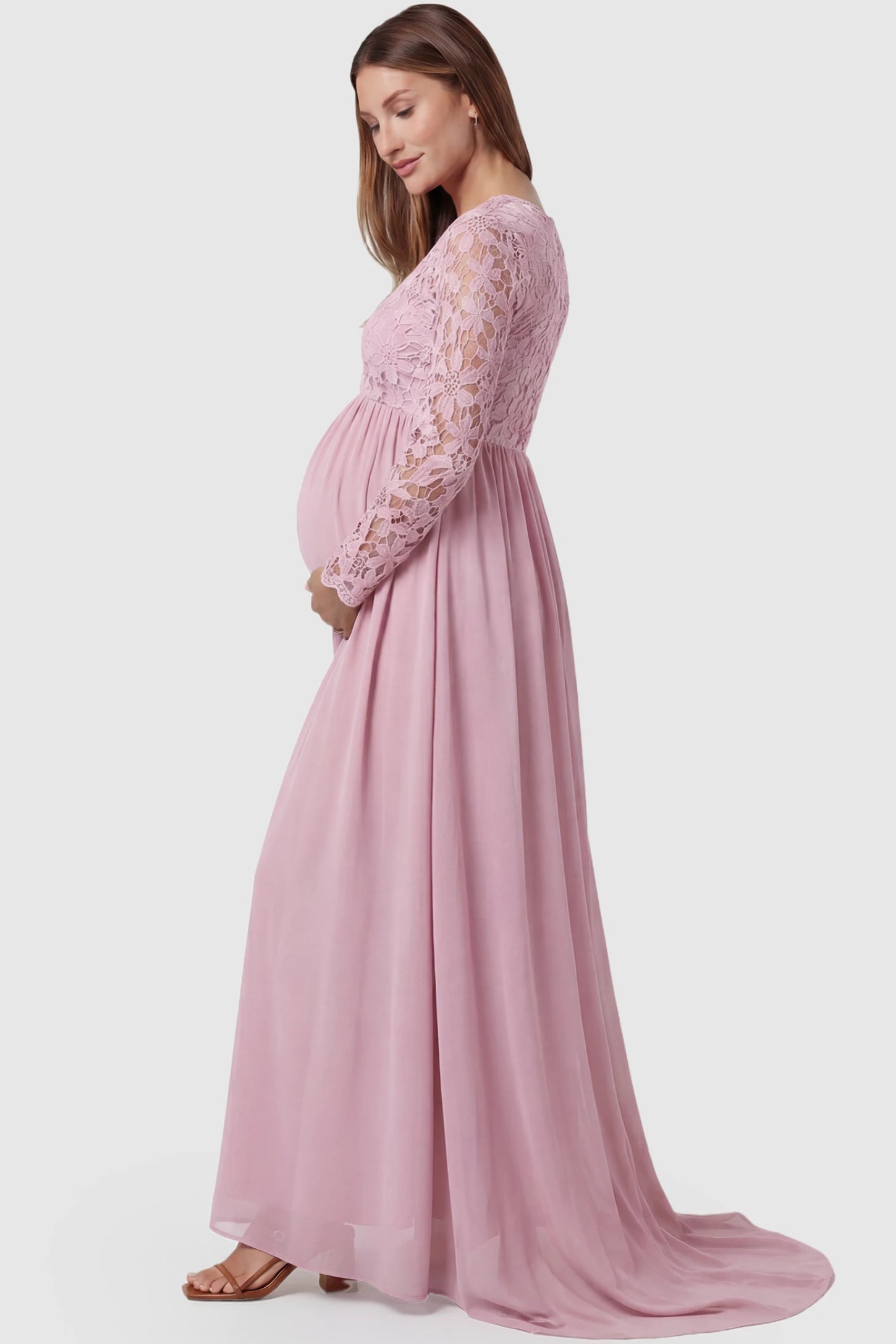 Lace Long Sleeve Full Skirt Maxi Maternity Dress Lace long sleeve full skirt maxi maternity dress in pink with elegant long sleeves & lace bodice, side view on pregnant model