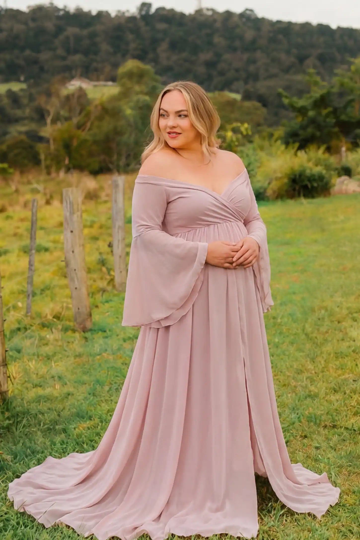 Off-the-Shoulder Long Train Maxi Maternity Dress Off-the-shoulder long train maxi maternity dress in pink featuring off-shoulder and long-train in full body front view on a editorial lifestyle model