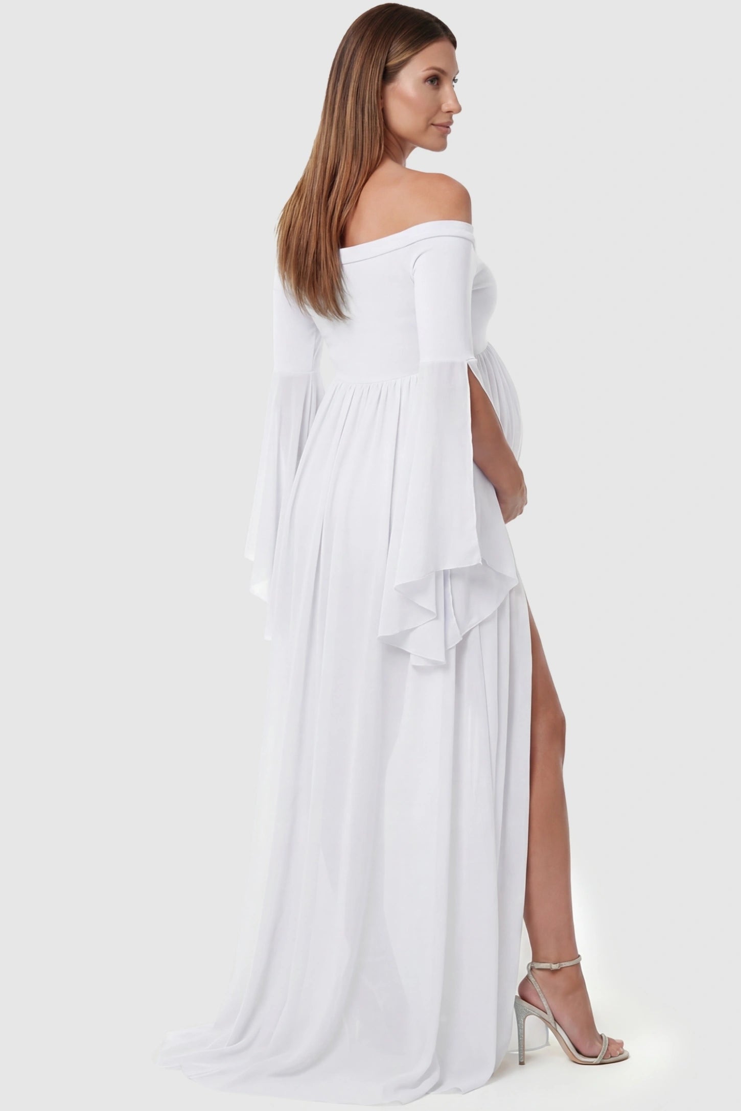 Off-the-Shoulder Long Train Maxi Maternity Dress Off-the-shoulder long train maxi maternity dress in white featuring flowing chiffon silhouette in full body back view on a pregnant model