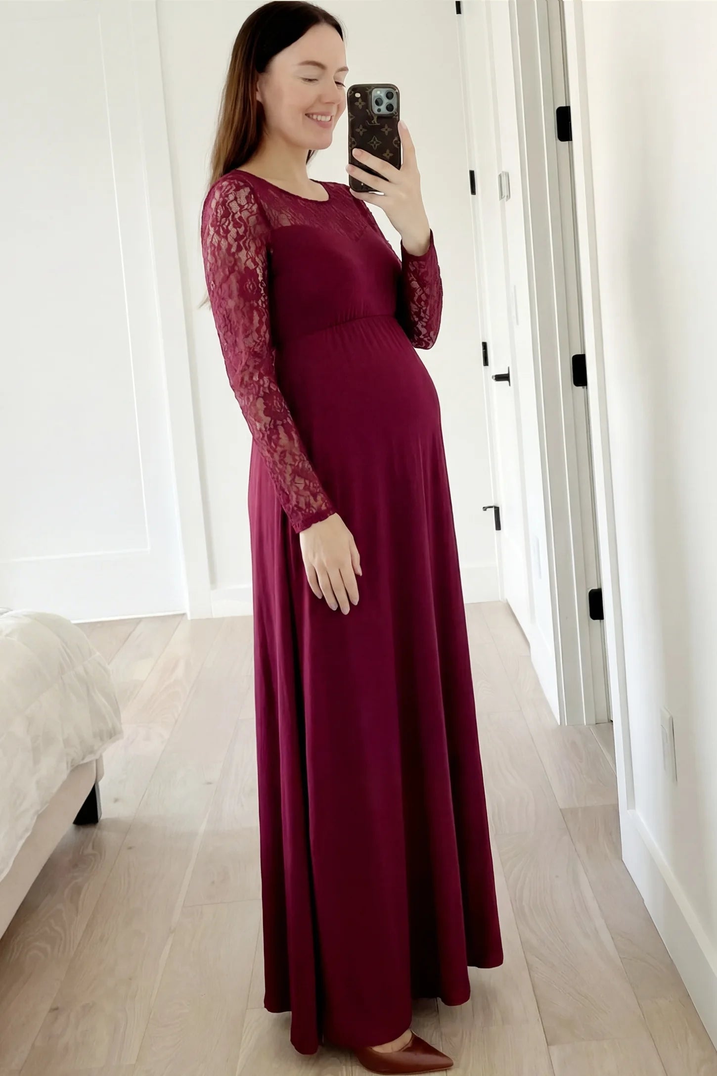 Acrylic Lace Long Sleeve Floor-Length Maternity Dress Acrylic Lace Long Sleeve Floor-Length Maternity Dress in Wine Red featuring a round neck on a pregnant model.