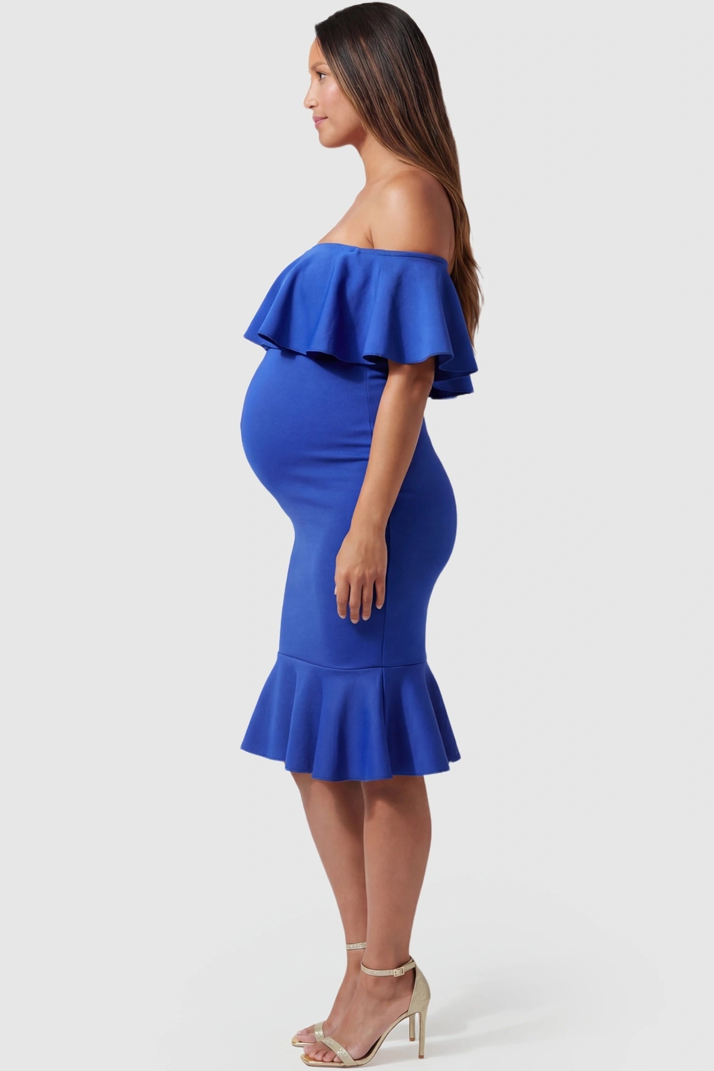 Ruffled Off-Shoulder Mermaid Hem Midi Maternity Dress Ruffled off-shoulder mermaid hem midi maternity dress in dark blue featuring curve-enhancing mermaid hem in side view on a pregnant model