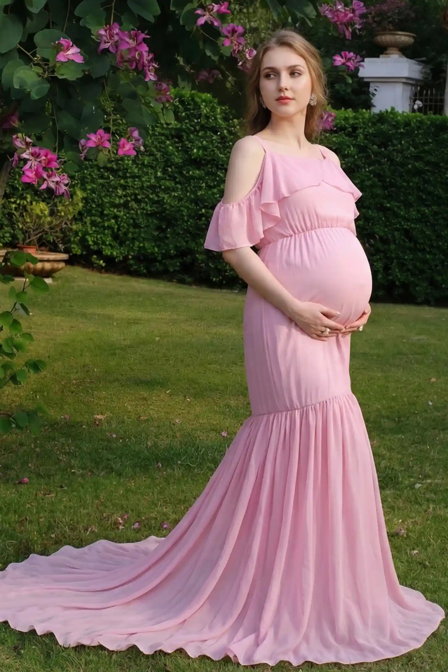 Off-Shoulder Flutter Sleeve Mermaid Trailing Maxi Maternity Dress Off-shoulder flutter sleeve mermaid trailing maxi maternity dress in pink with double-layered skirt, on editorial lifestyle model