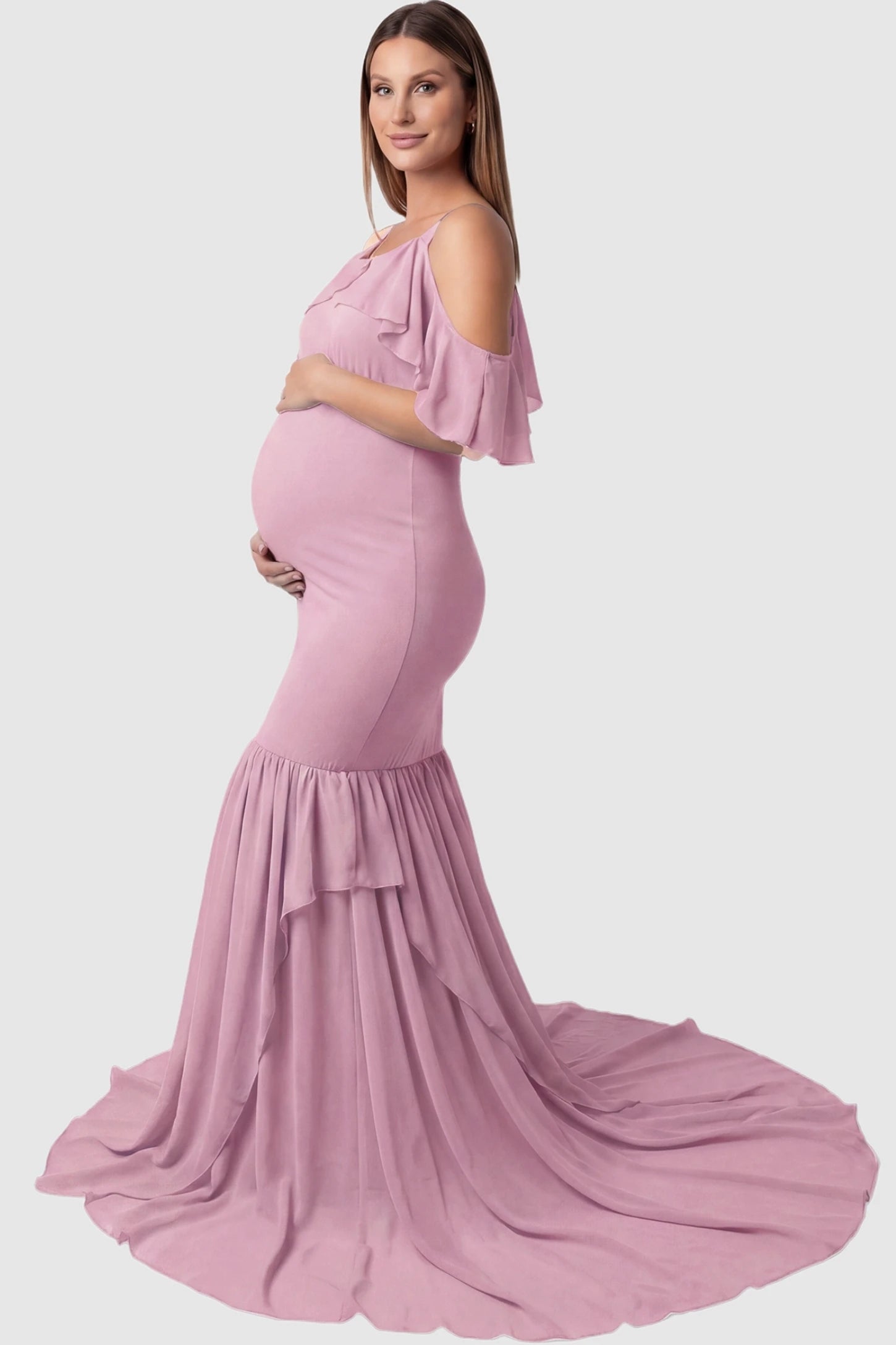 Off-Shoulder Flutter Sleeve Mermaid Trailing Maxi Maternity Dress Off-shoulder flutter sleeve mermaid trailing maxi maternity dress in pink featuring flowing double-layered skirt in side view on a pregnant model