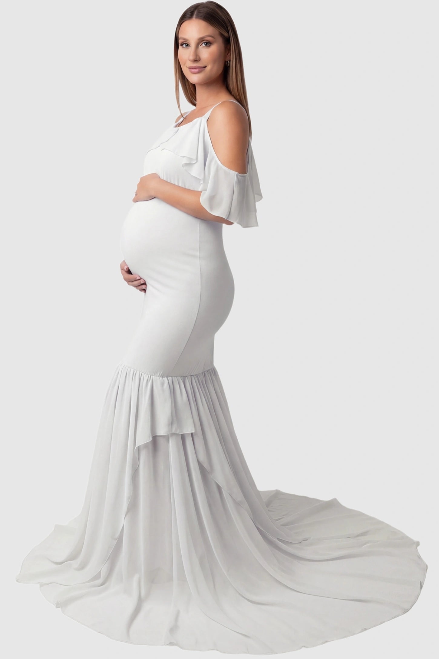 Off-Shoulder Flutter Sleeve Mermaid Trailing Maxi Maternity Dress Off-shoulder flutter sleeve mermaid trailing maxi maternity dress in white featuring flowing double-layered skirt in side view on a pregnant model