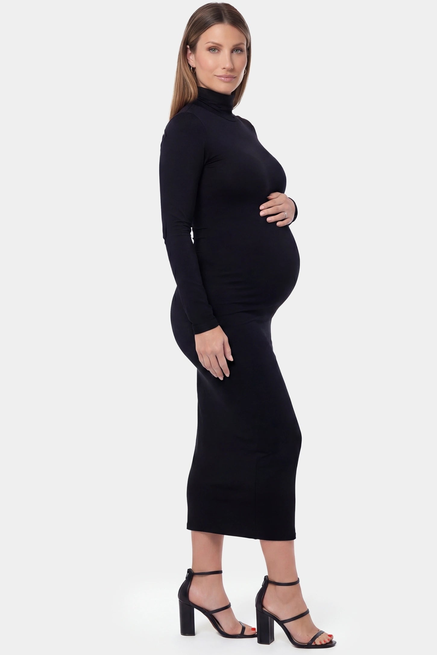 Fitted Long Sleeve Mock Neck Maxi Maternity Dress Fitted long sleeve mock neck maxi maternity dress in black with bump-contouring fit, side view on pregnant model