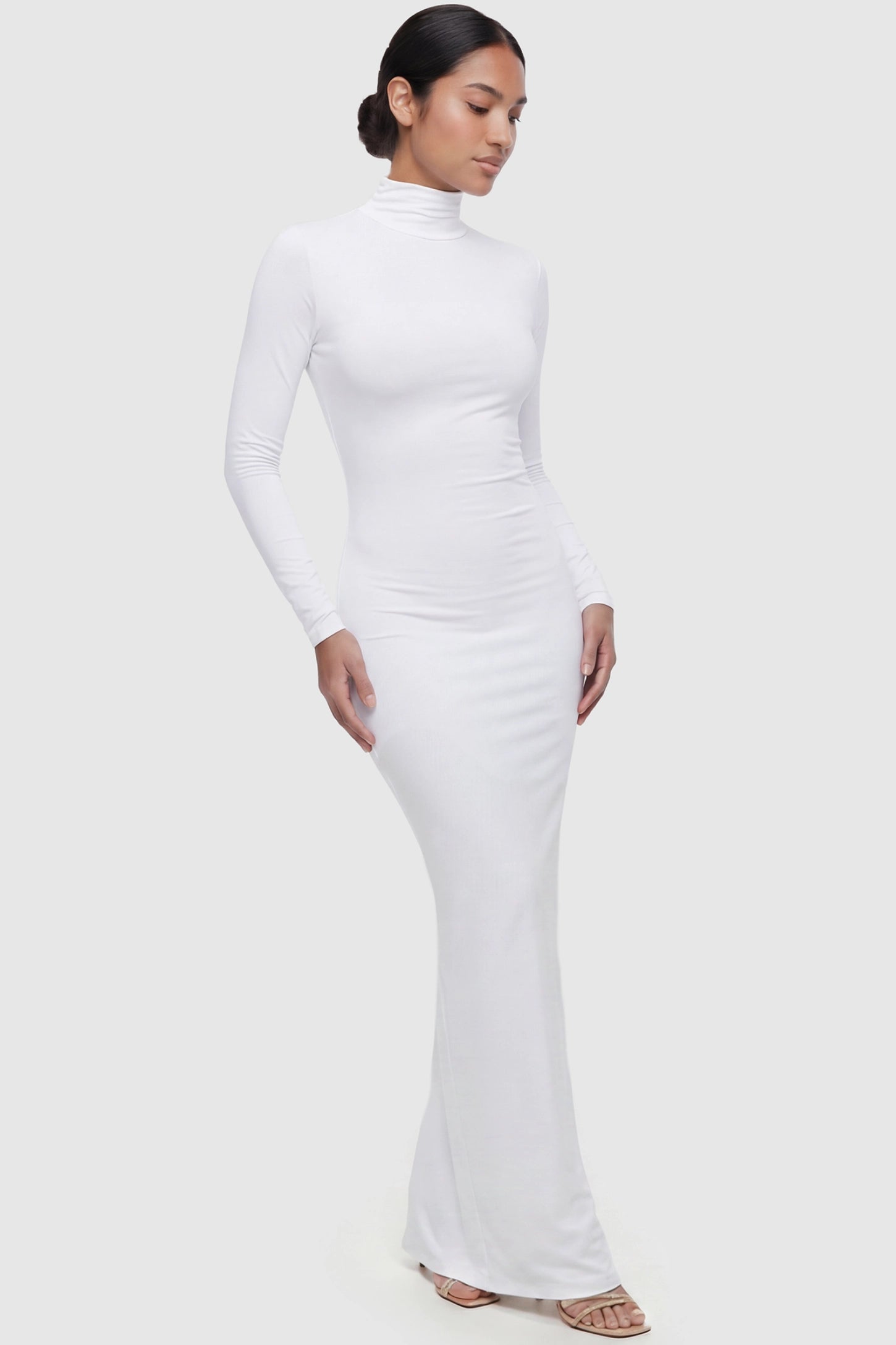 Fitted Long Sleeve Mock Neck Maxi Maternity Dress Fitted long sleeve mock neck maxi maternity dress in white with mock neckline, front view on postpartum model