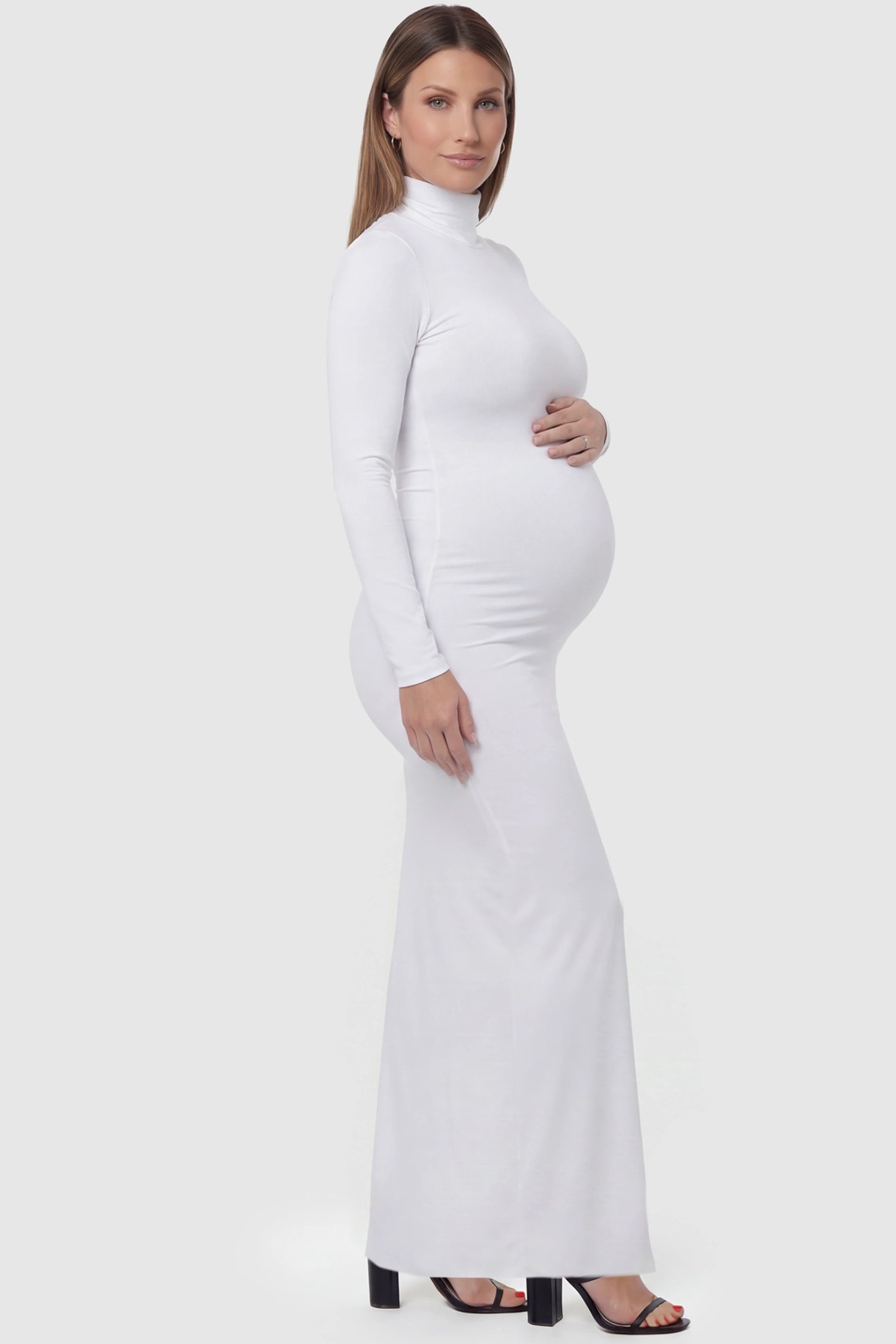 Fitted long sleeve mock neck maxi maternity dress in white with mock neckline, side view on pregnant model