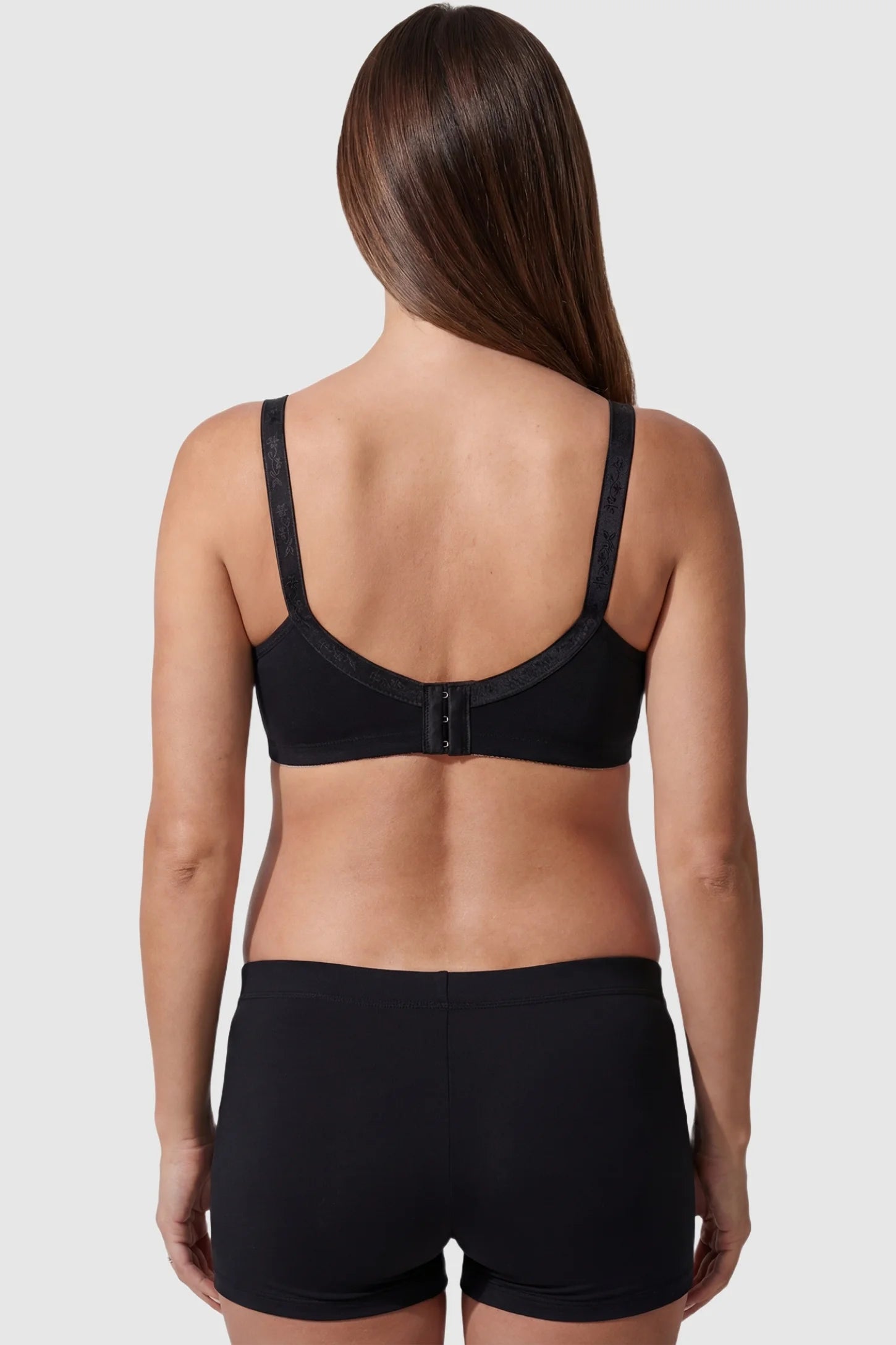 Wireless medium molded cup open-clasp nursing bra in black with 3-row hook closure, back view on pregnant model