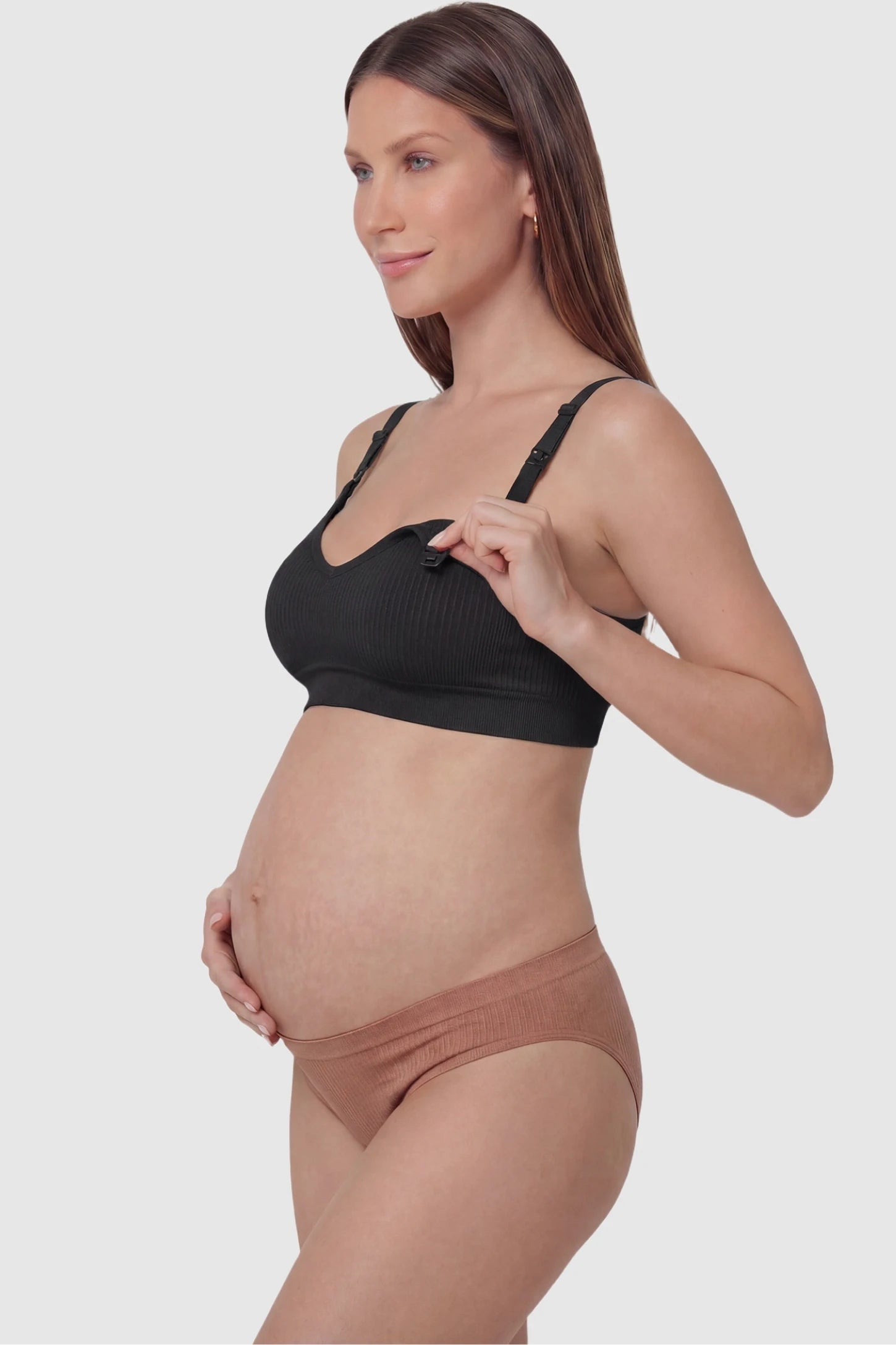 Ribbed Wireless Adjustable Shoulder Strap Nursing Bra Ribbed wireless adjustable strap nursing bra in black with front open clasp for breastfeeding, side view on pregnant model