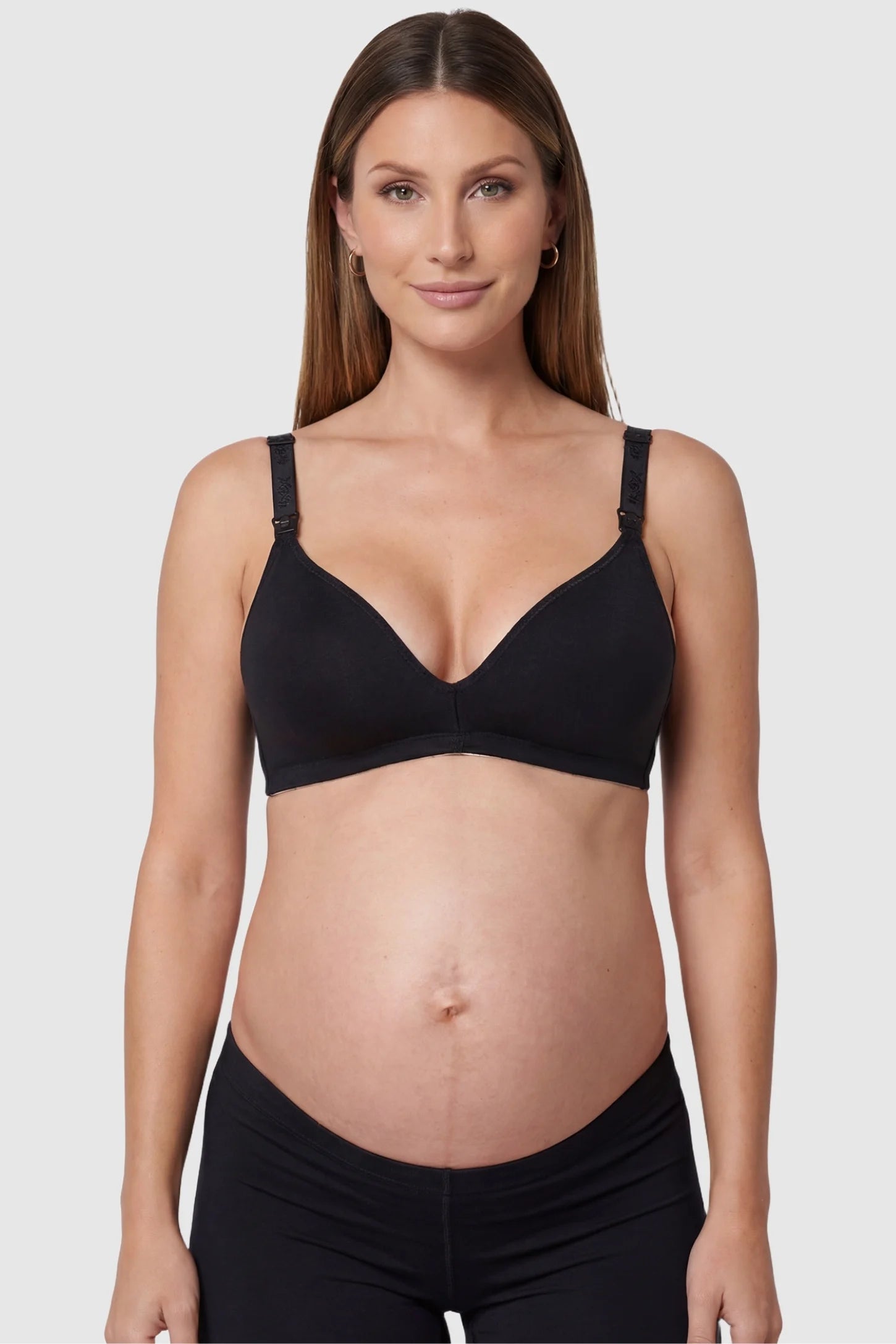 Wireless medium molded cup open-clasp nursing bra in black with molded cups, front view on pregnant model