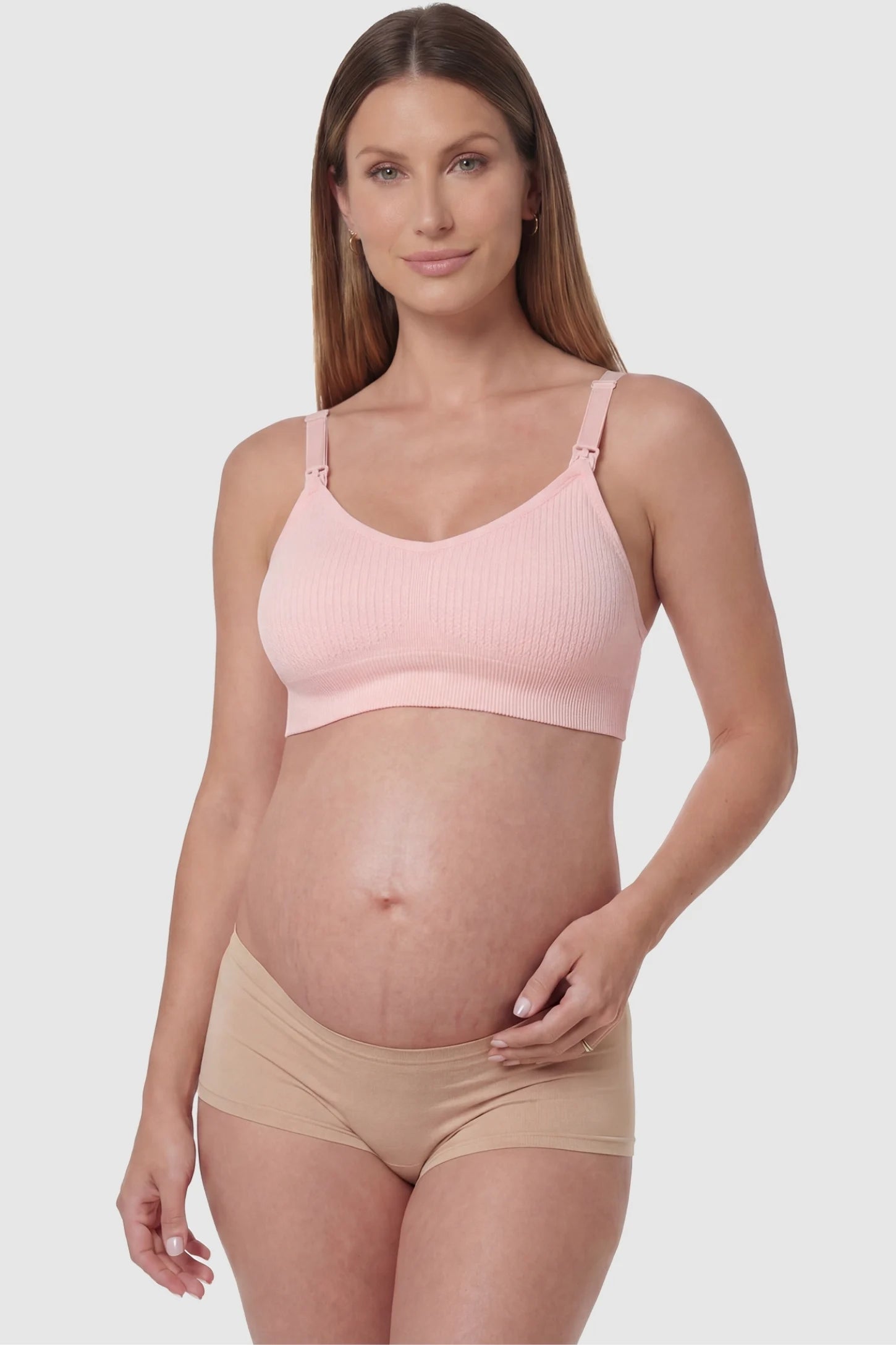 Full-Flap Seamless Top-Opening Nursing Bra Full-flap seamless top-opening nursing bra in light pink with 3D support, front view on pregnant model