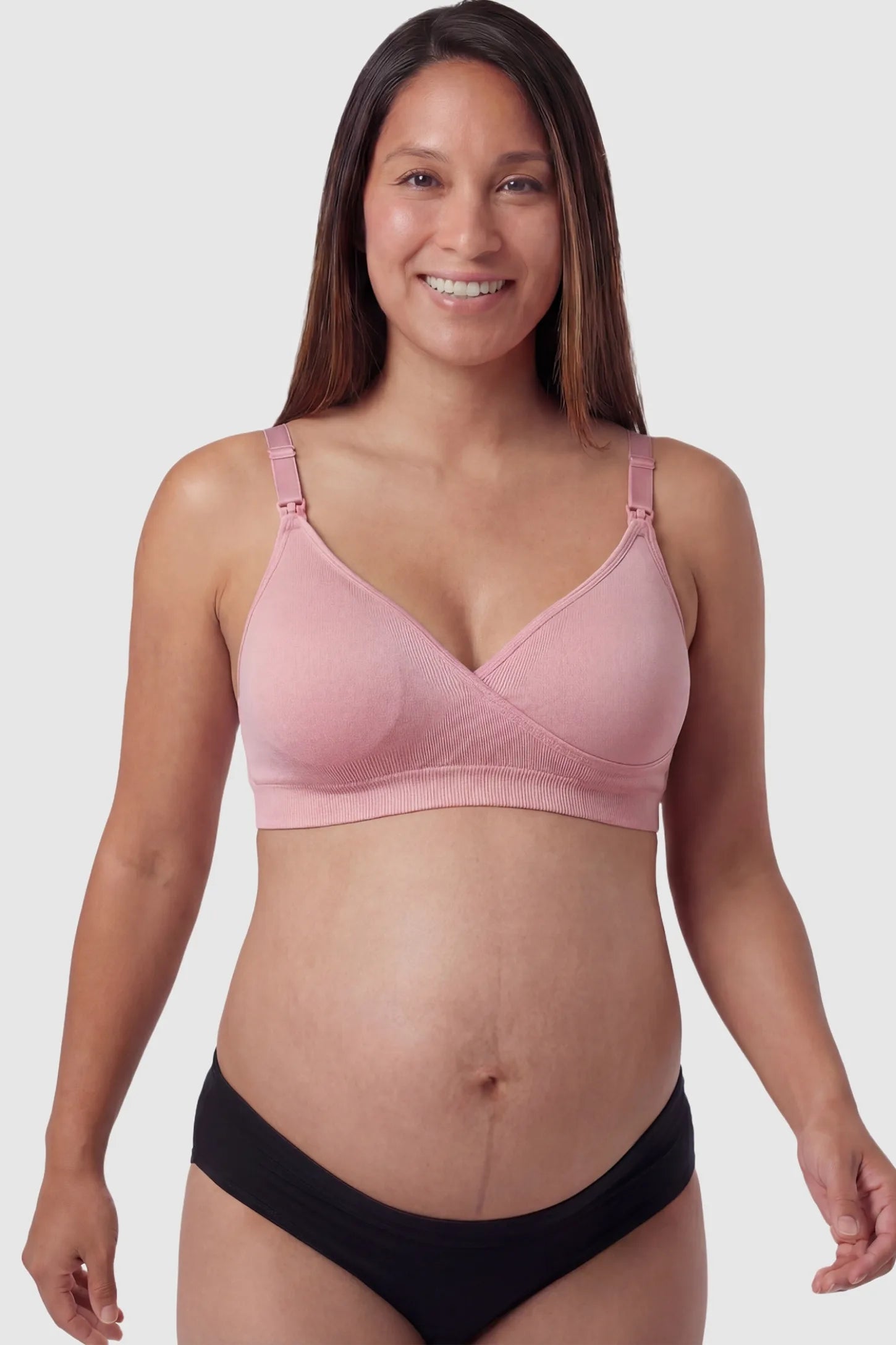 Seamless front-open cross wireless nursing bra in peach red with cross front access, front view on pregnant model