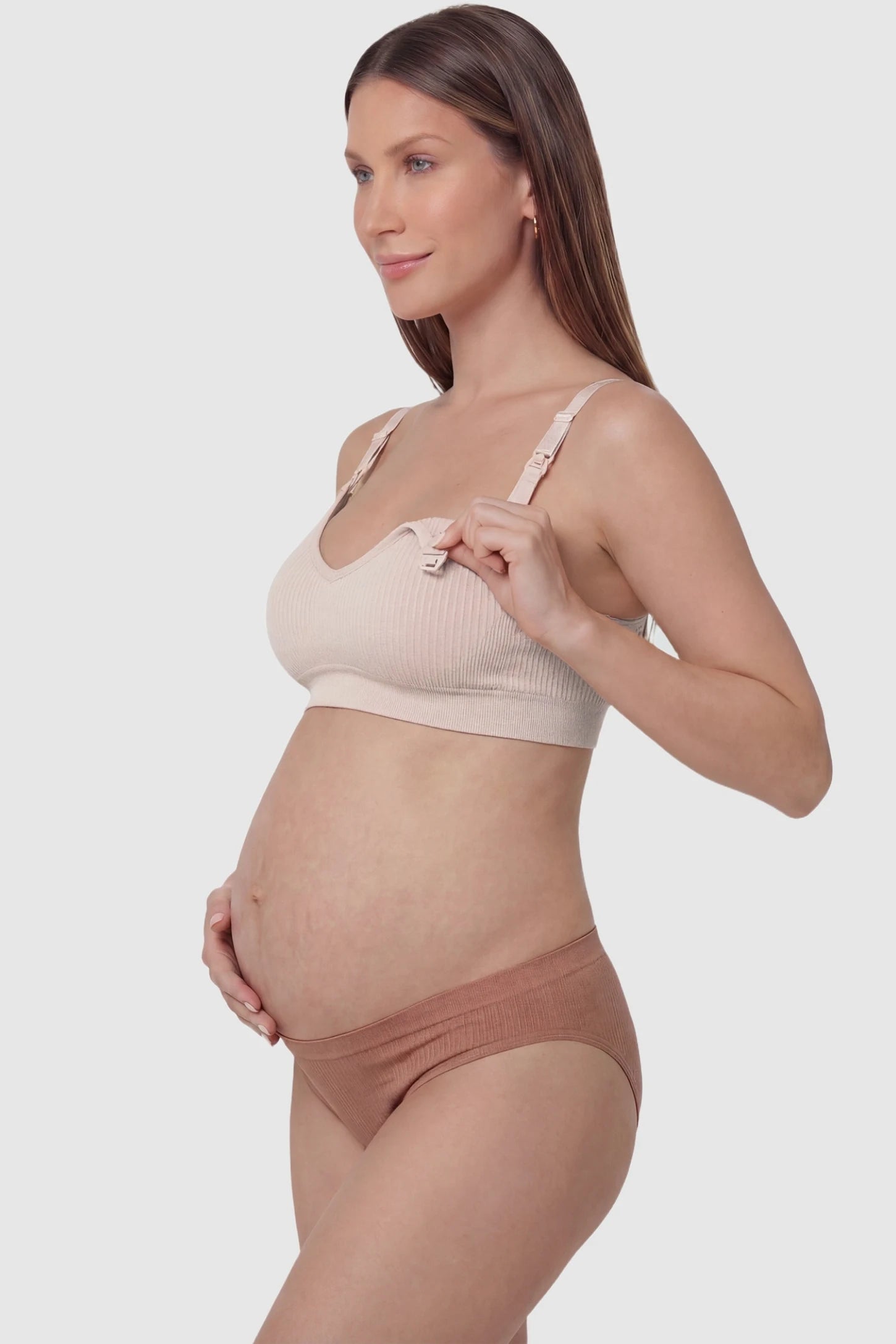 Ribbed Wireless Adjustable Shoulder Strap Nursing Bra Ribbed wireless adjustable strap nursing bra in pink with front open clasp for breastfeeding, side view on pregnant model