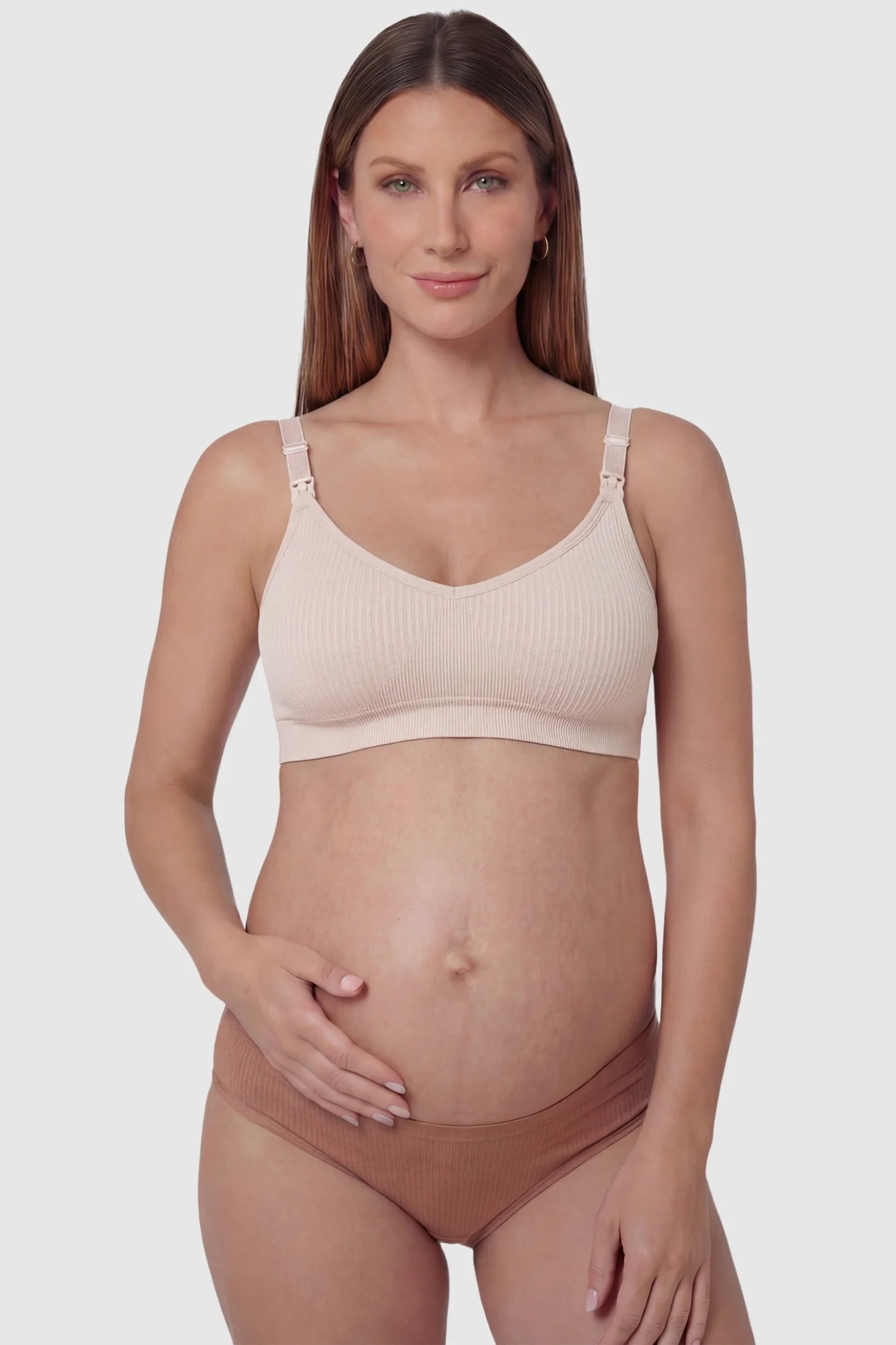 Ribbed Wireless Adjustable Shoulder Strap Nursing Bra Ribbed wireless adjustable strap nursing bra in pink with front clasp, front view on pregnant model
