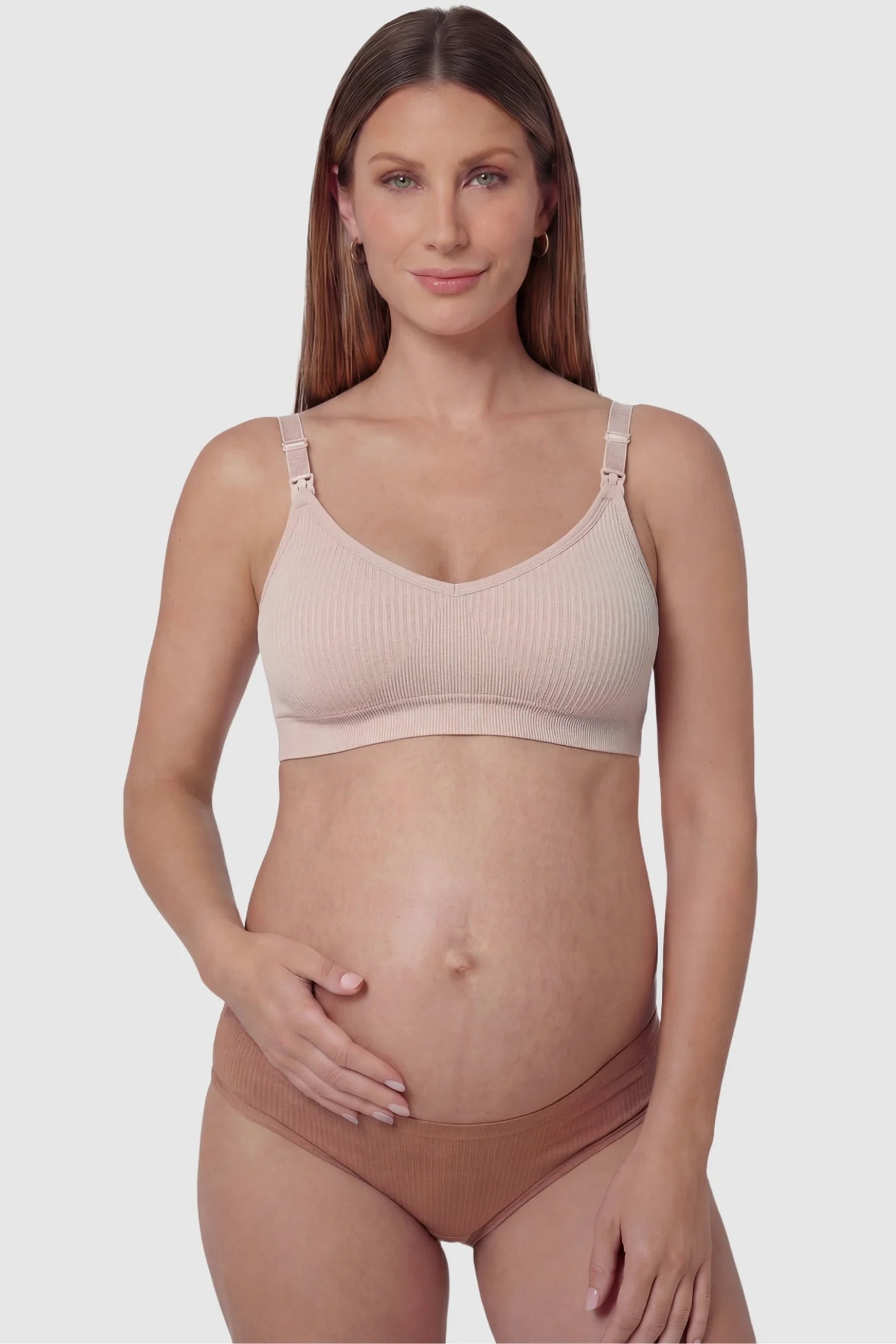 Ribbed Wireless Adjustable Shoulder Strap Nursing Bra Ribbed wireless adjustable strap nursing bra in pink with front clasp, front view on pregnant model