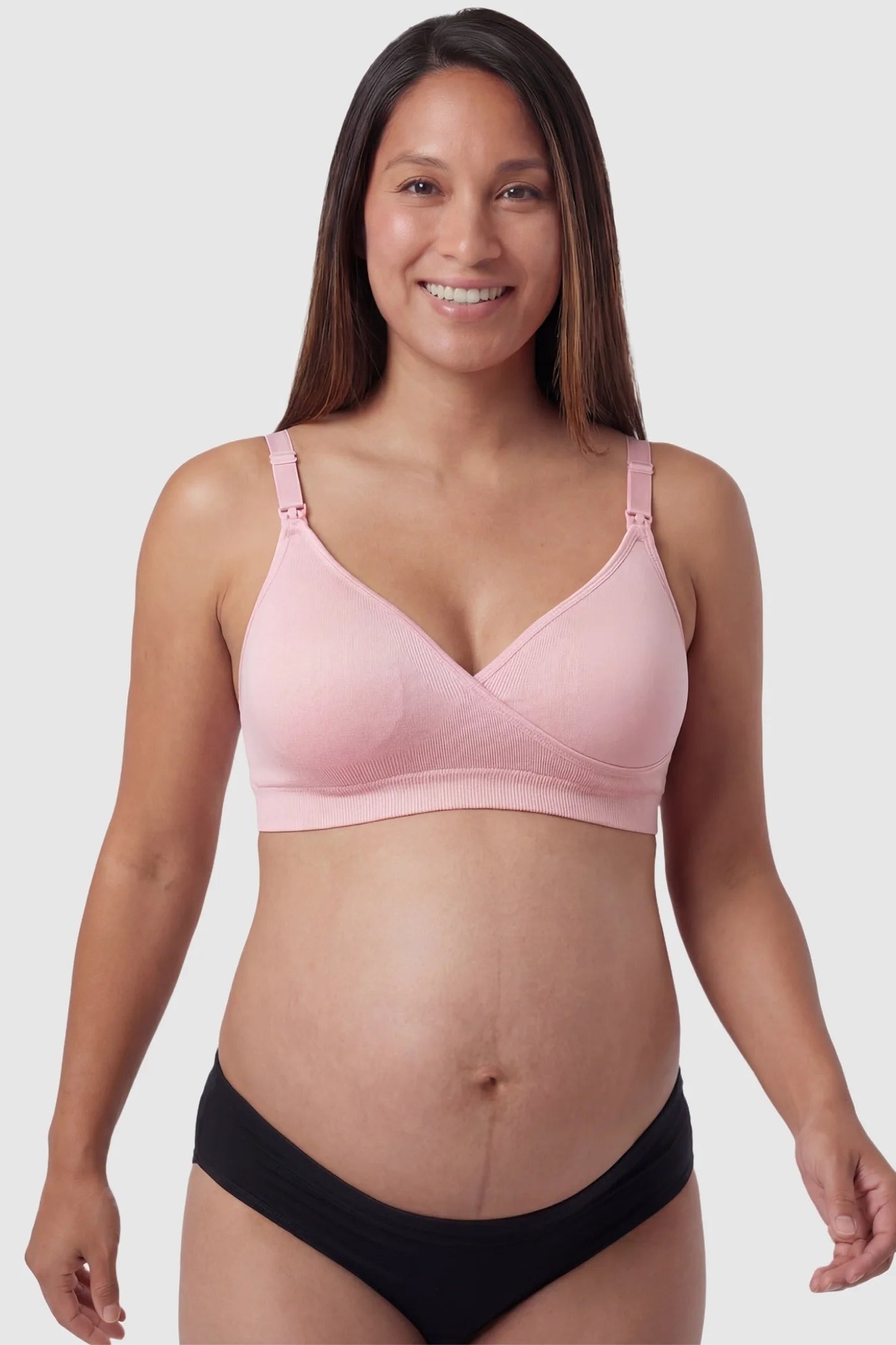 Seamless Front-Open Cross Wireless Nursing Bra Seamless front-open cross wireless nursing bra in pink with cross front access, front view on pregnant model