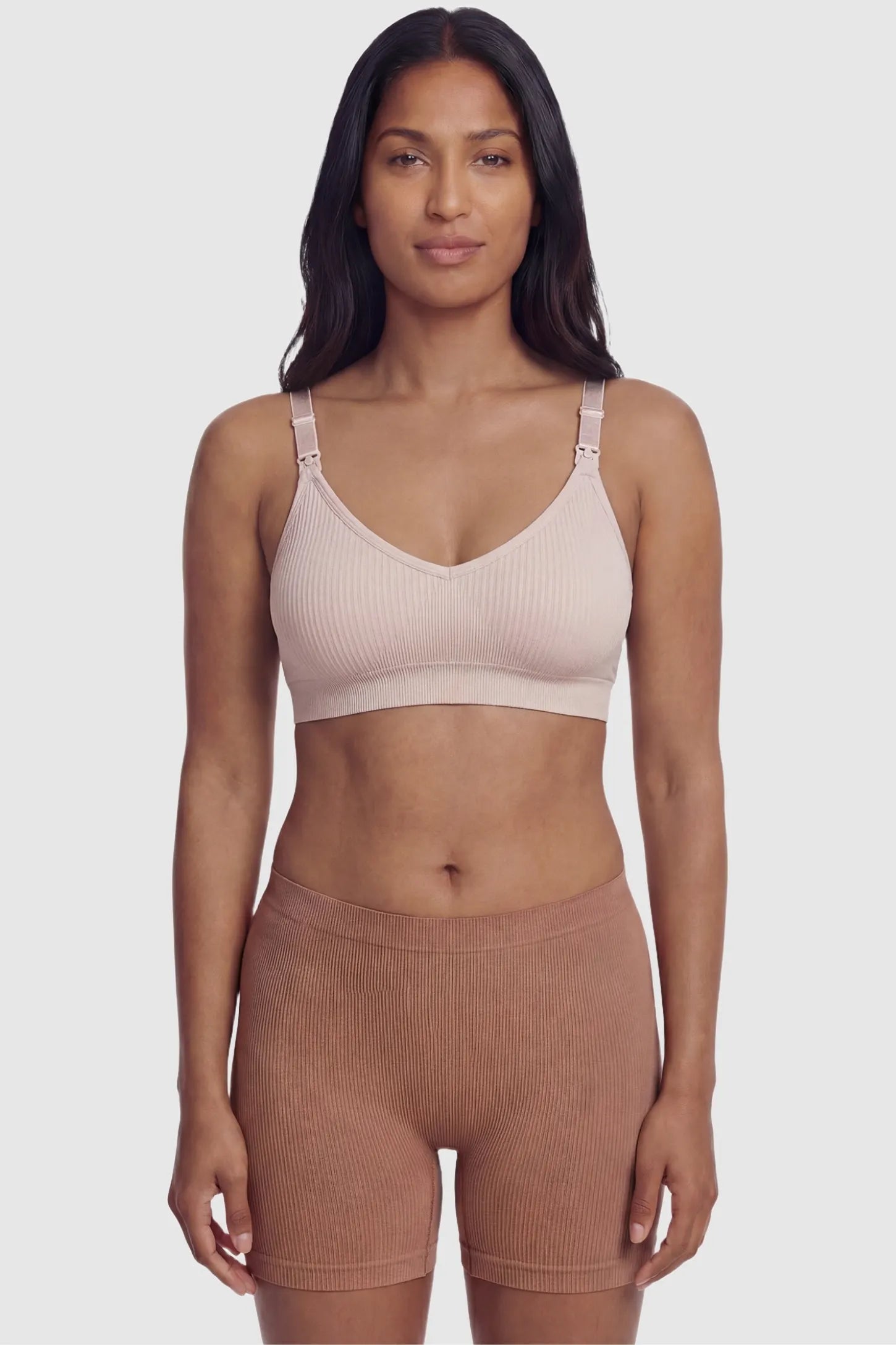 Ribbed Wireless Adjustable Shoulder Strap Nursing Bra Ribbed wireless adjustable strap nursing bra in pink with stretchy fabric, front view on postpartum model