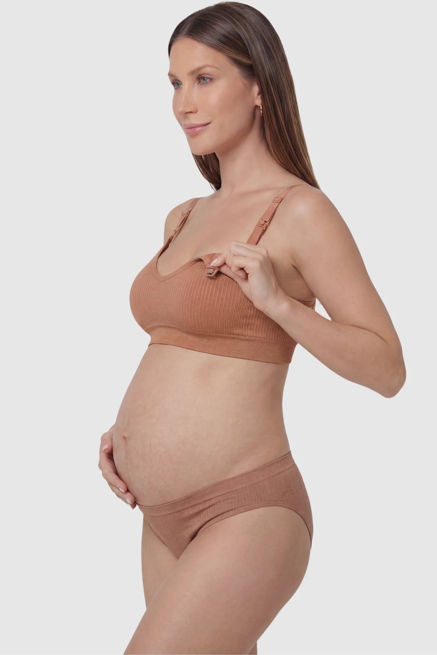 Ribbed Wireless Adjustable Shoulder Strap Nursing Bra Ribbed wireless adjustable strap nursing bra in shrimp red with front open clasp for breastfeeding, side view on pregnant model