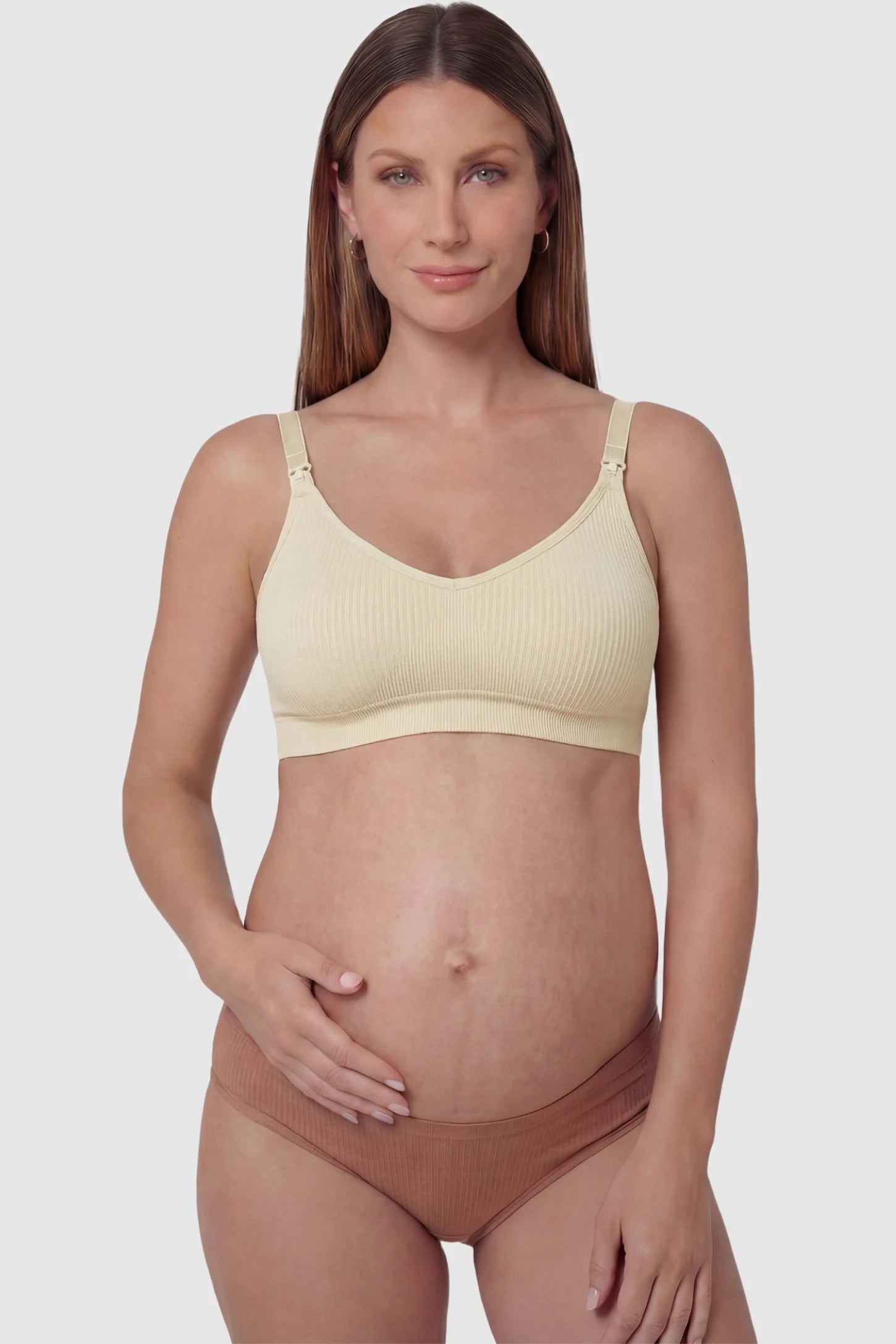 Ribbed Wireless Adjustable Shoulder Strap Nursing Bra Ribbed wireless adjustable strap nursing bra in skin with front clasp, front view on pregnant model
