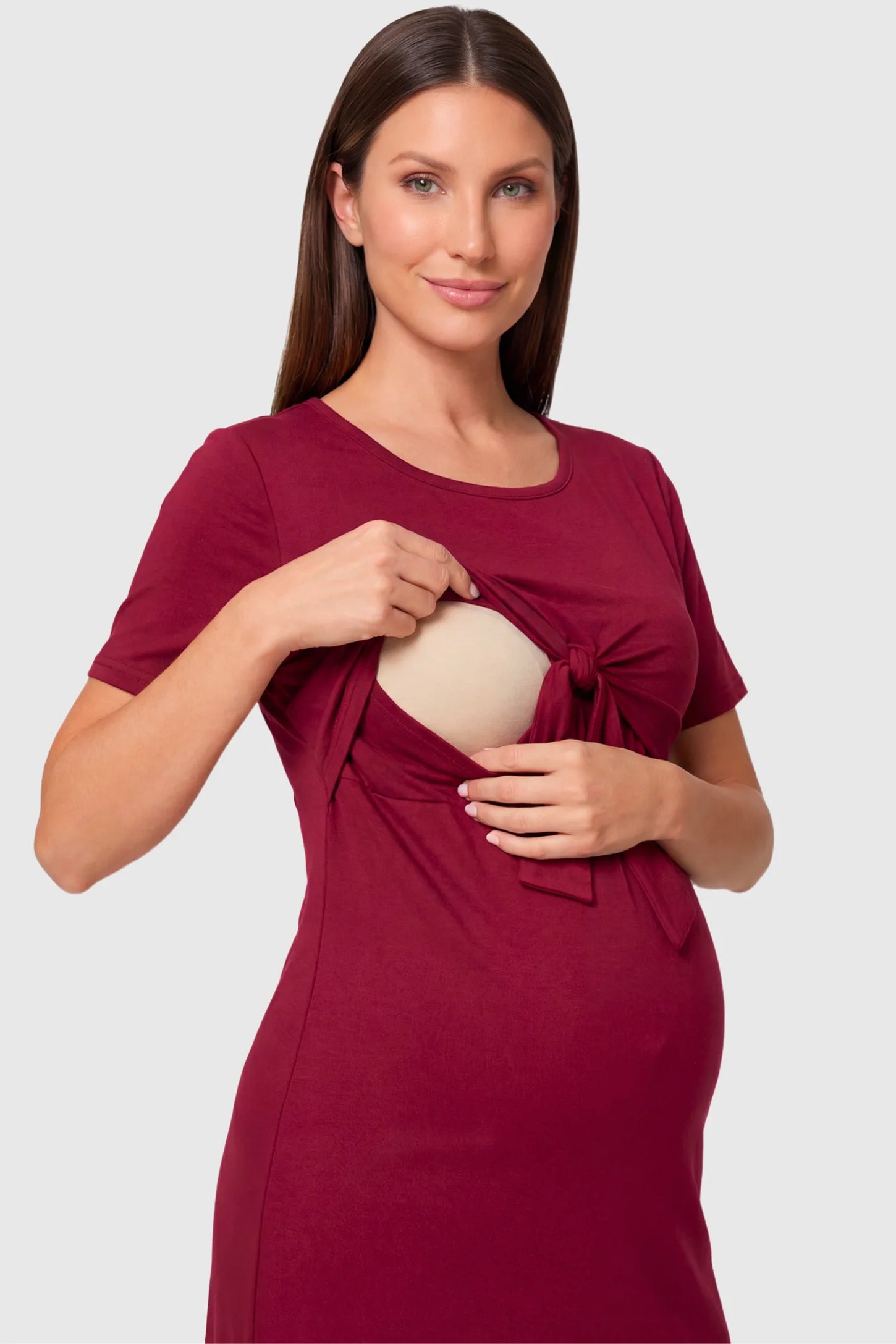 Crew Neck Bodycon Maternity & Nursing Midi Dress Crew Neck Bodycon Maternity & Nursing Midi Dress in wine red featuring twist-front detail and nursing access on a  pregnant model.
